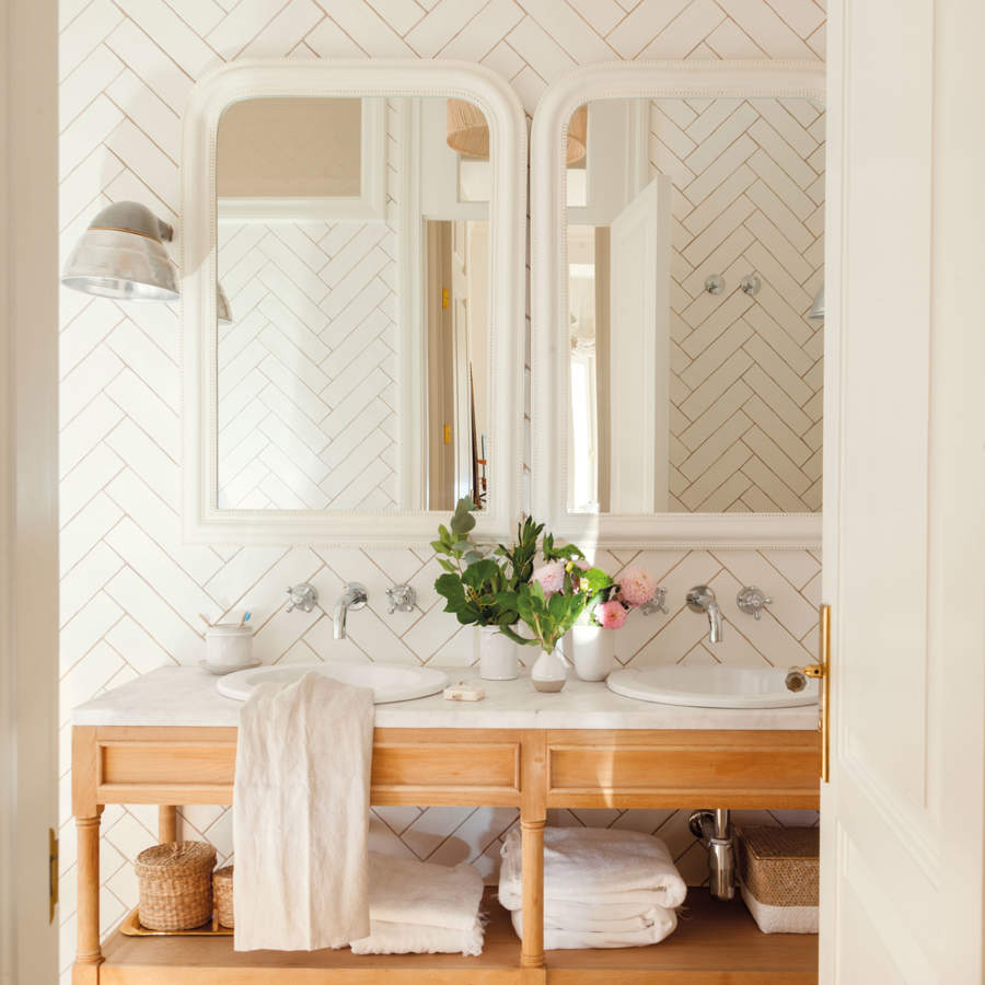 Mueble de baño abierto en madera con sobre de mármol, lavabos encastrados, espejos y azulejos metro en zigzag