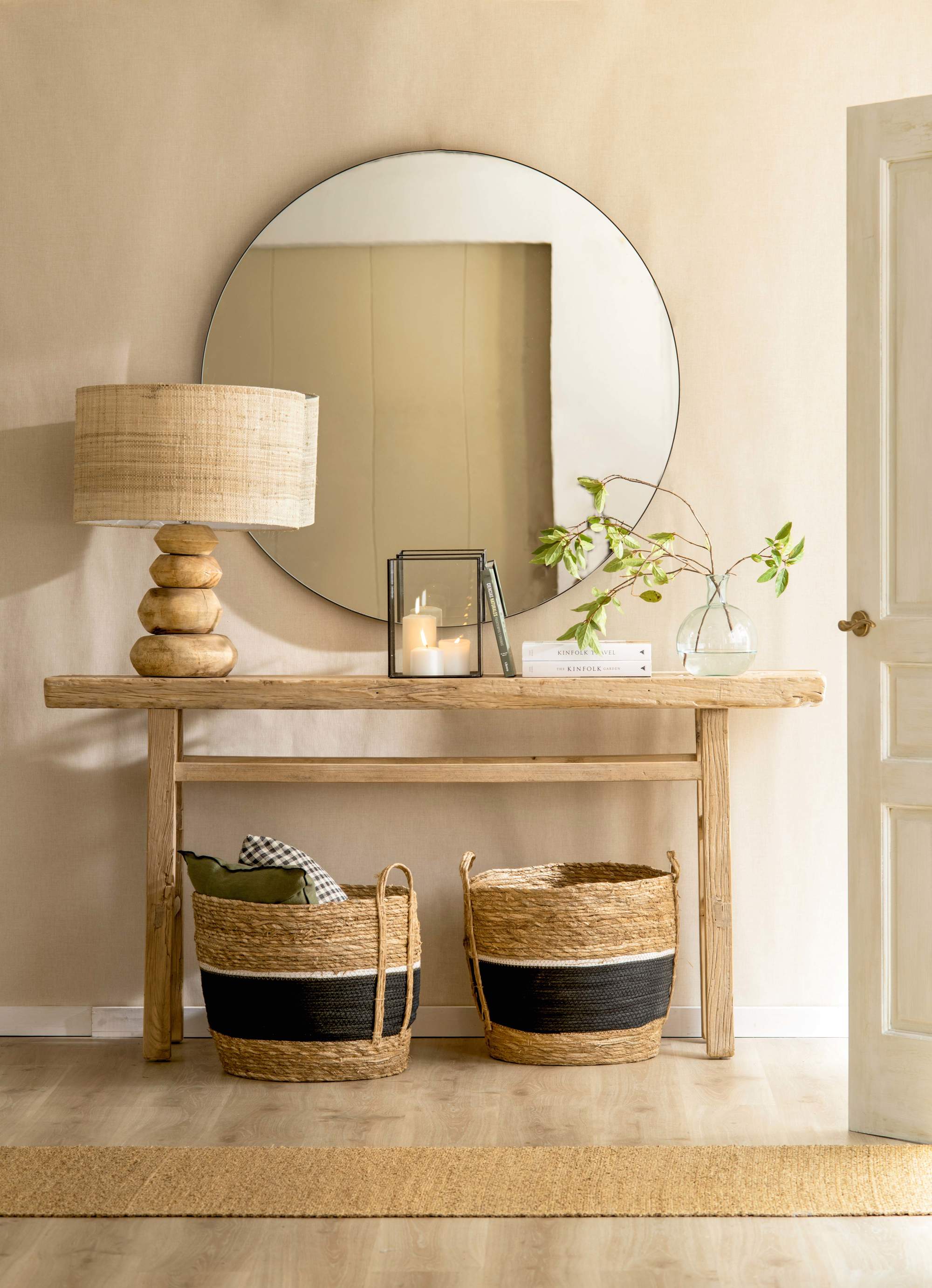 Consola de madera en recibidor pequeño con espejo, cestas y lámpara de sobremesa