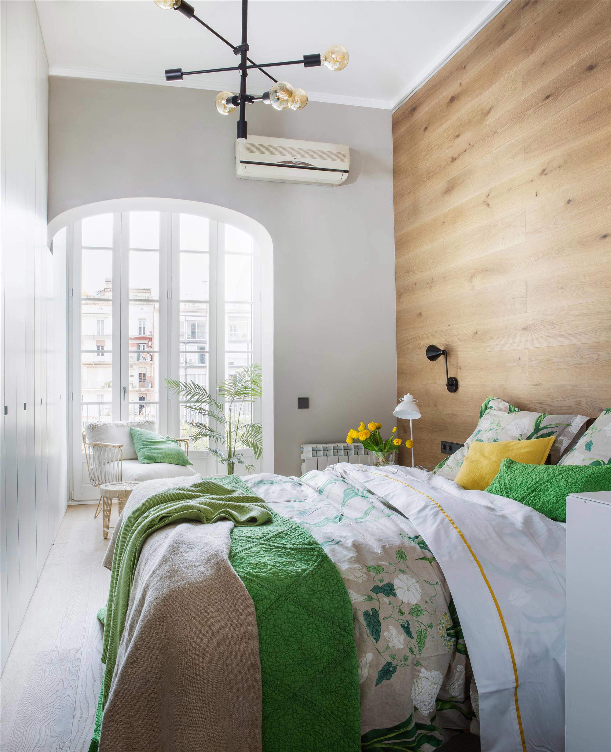 Dormitorio con pared cabecero revestida de madera