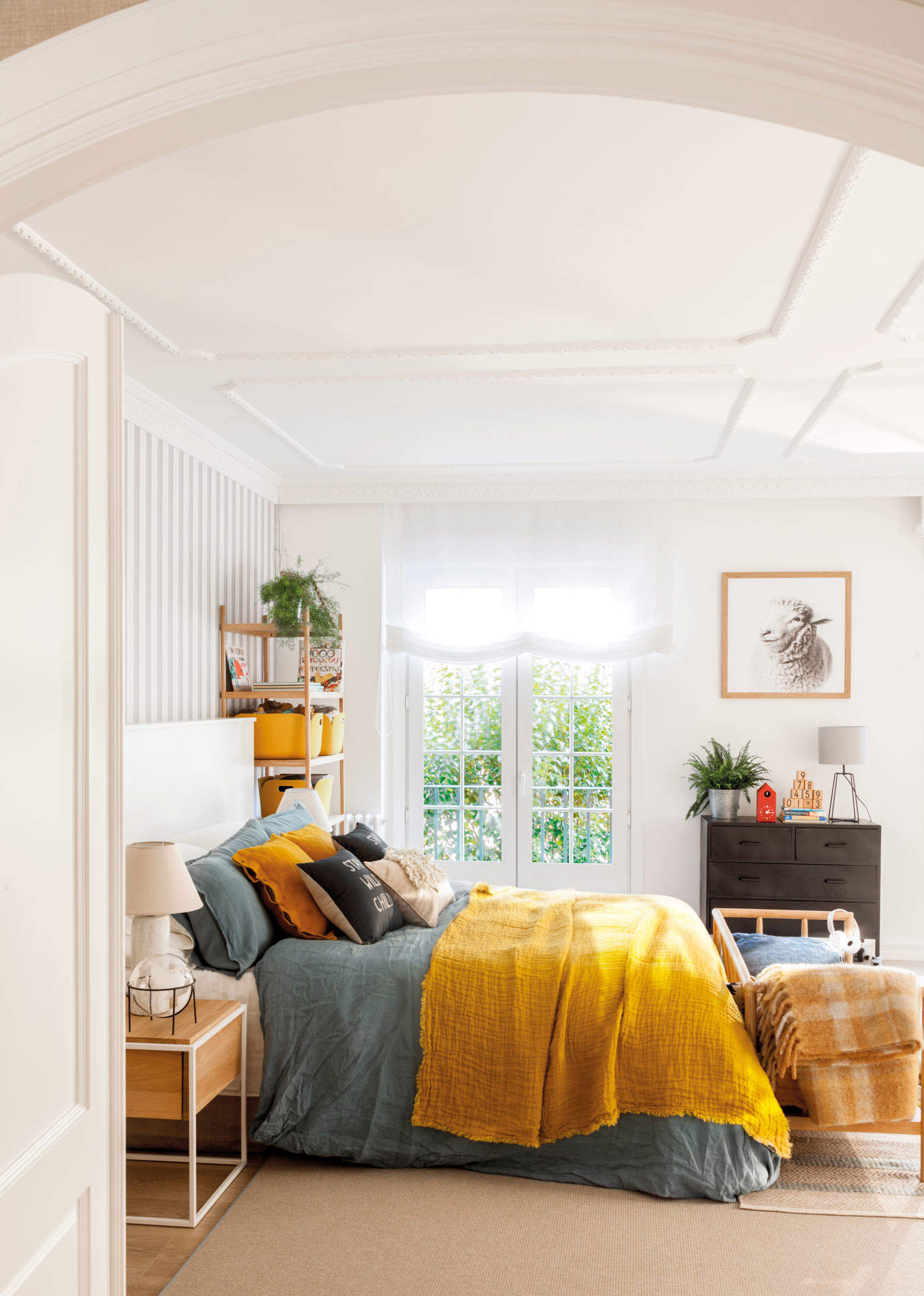 Dormitorio con techo decorado con molduras, papel pintado de rayas y ropa de cama de color
