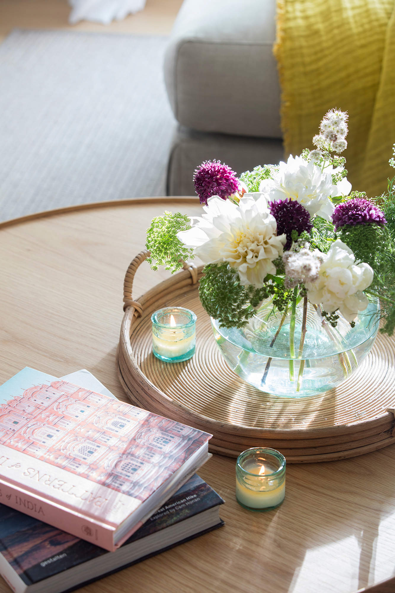 Detalle de velas y flores sobre una mesa de centro