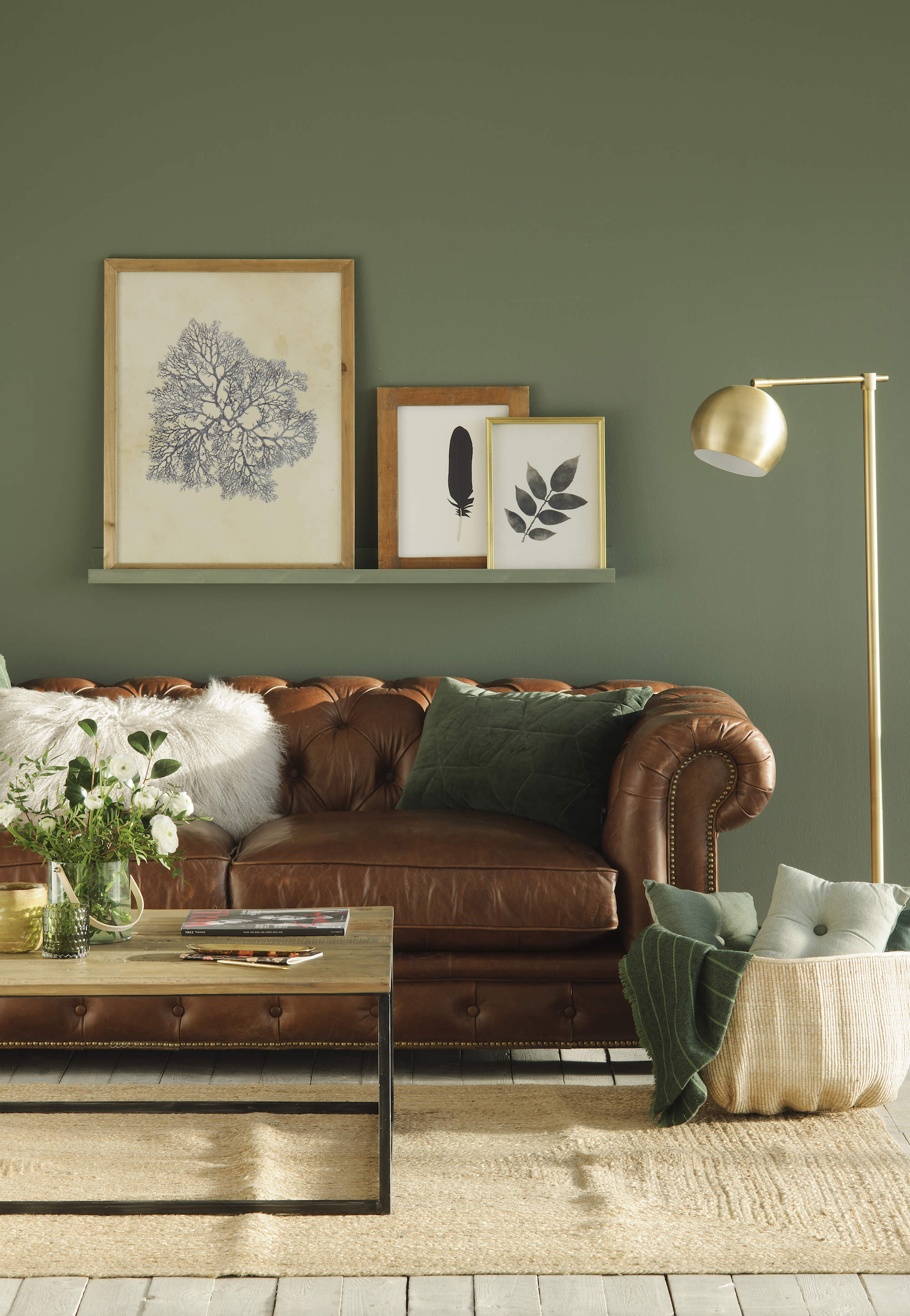 Salón pintado en verde con sofá de cuero