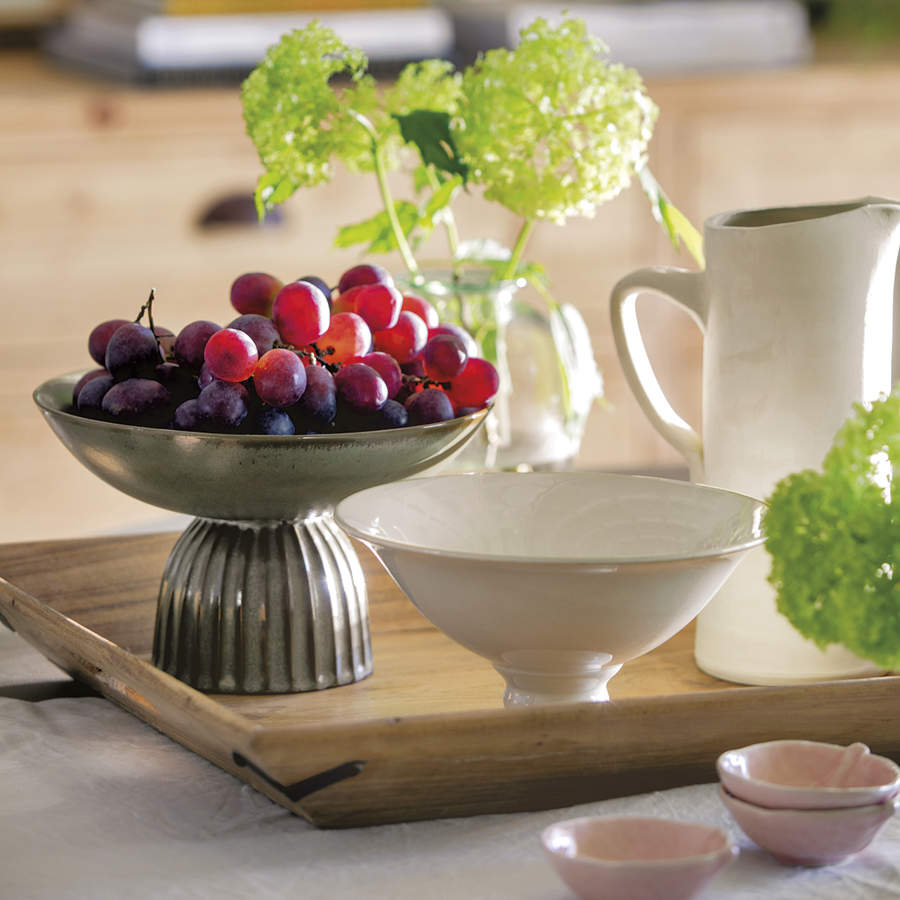 mesa de comedor con bandeja de madera con uvas, jarra y mantel blanco