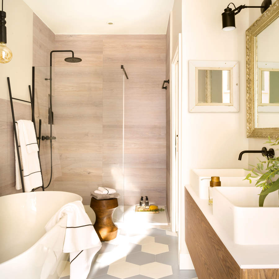 Baño con revestimiento beige, suelo cerámico hexagonal y bañera