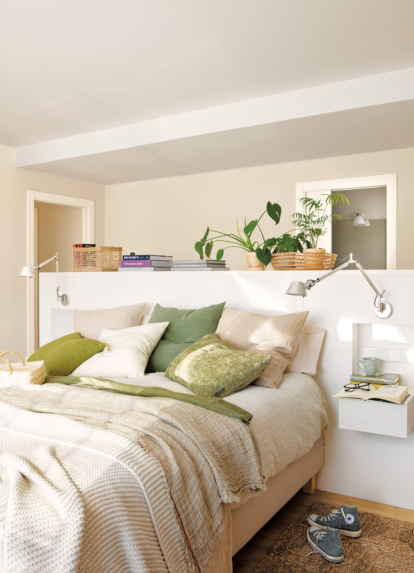 Dormitorio con cabecero exento a media altura y apliques de diseño