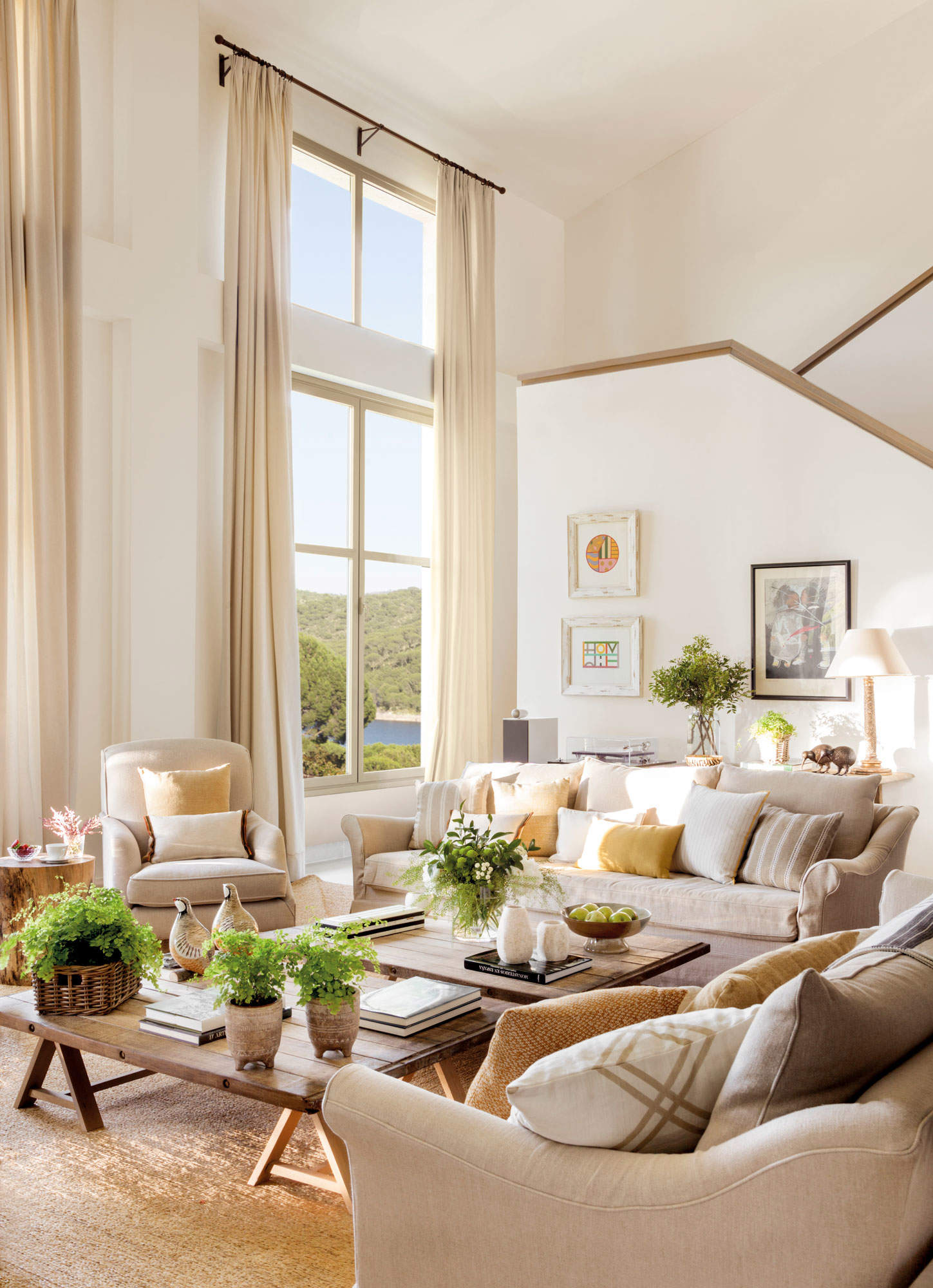 Salón con sofás de tapicerías blancas y mesas de madera