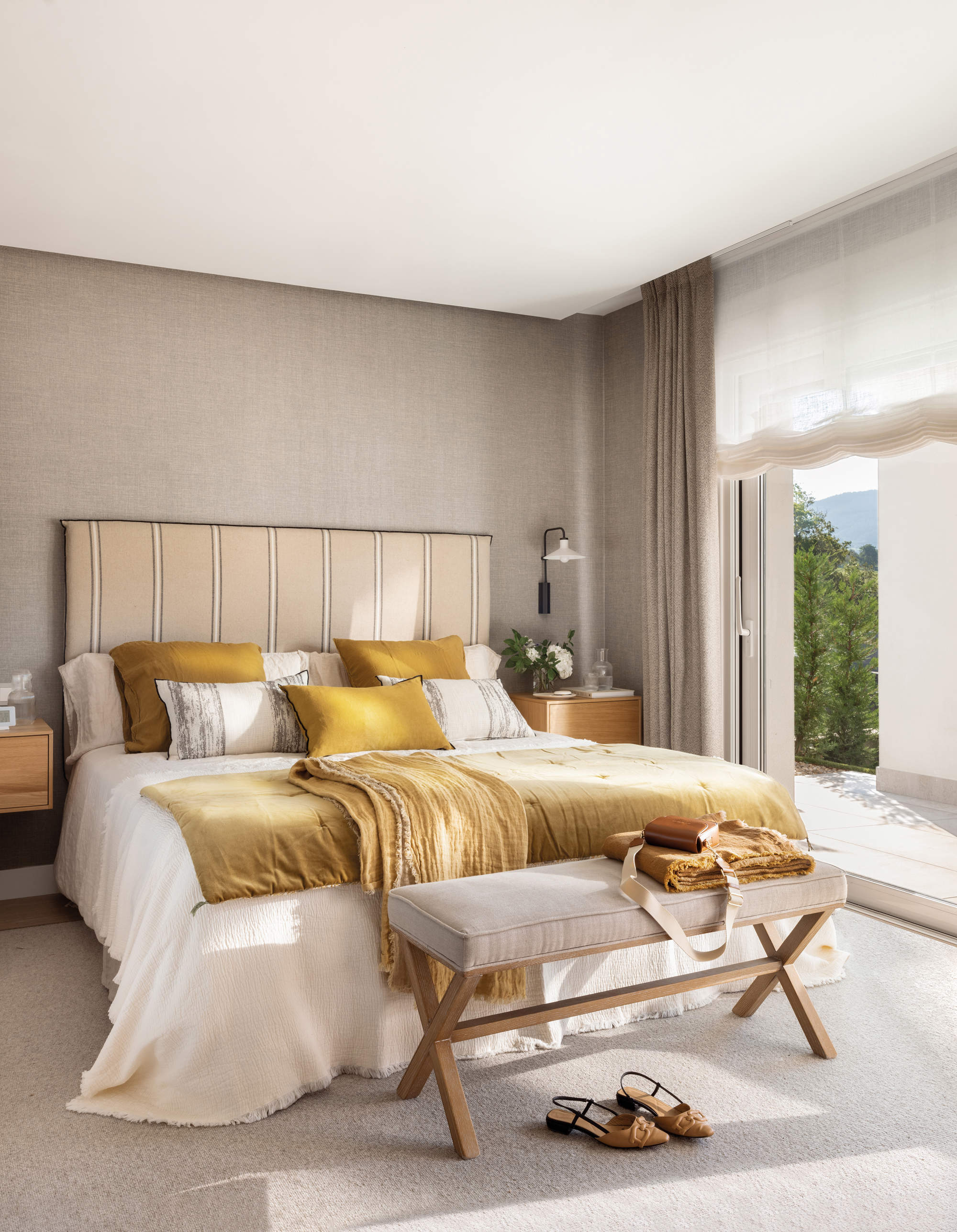 Dormitorio moderno con cabecero tapizado a rayas.