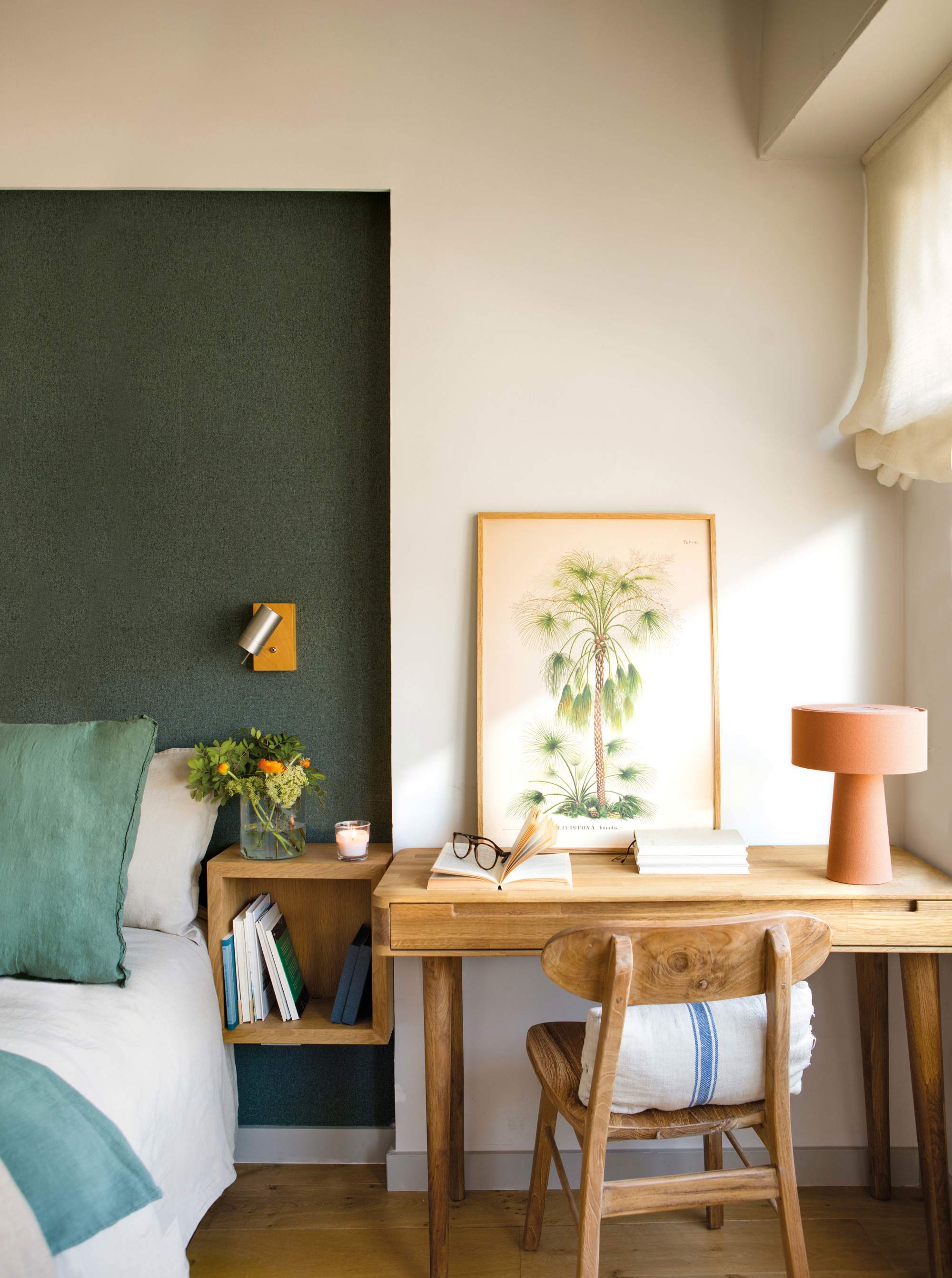Dormitorio con pared pintada en verde y escritorio junto a la cama