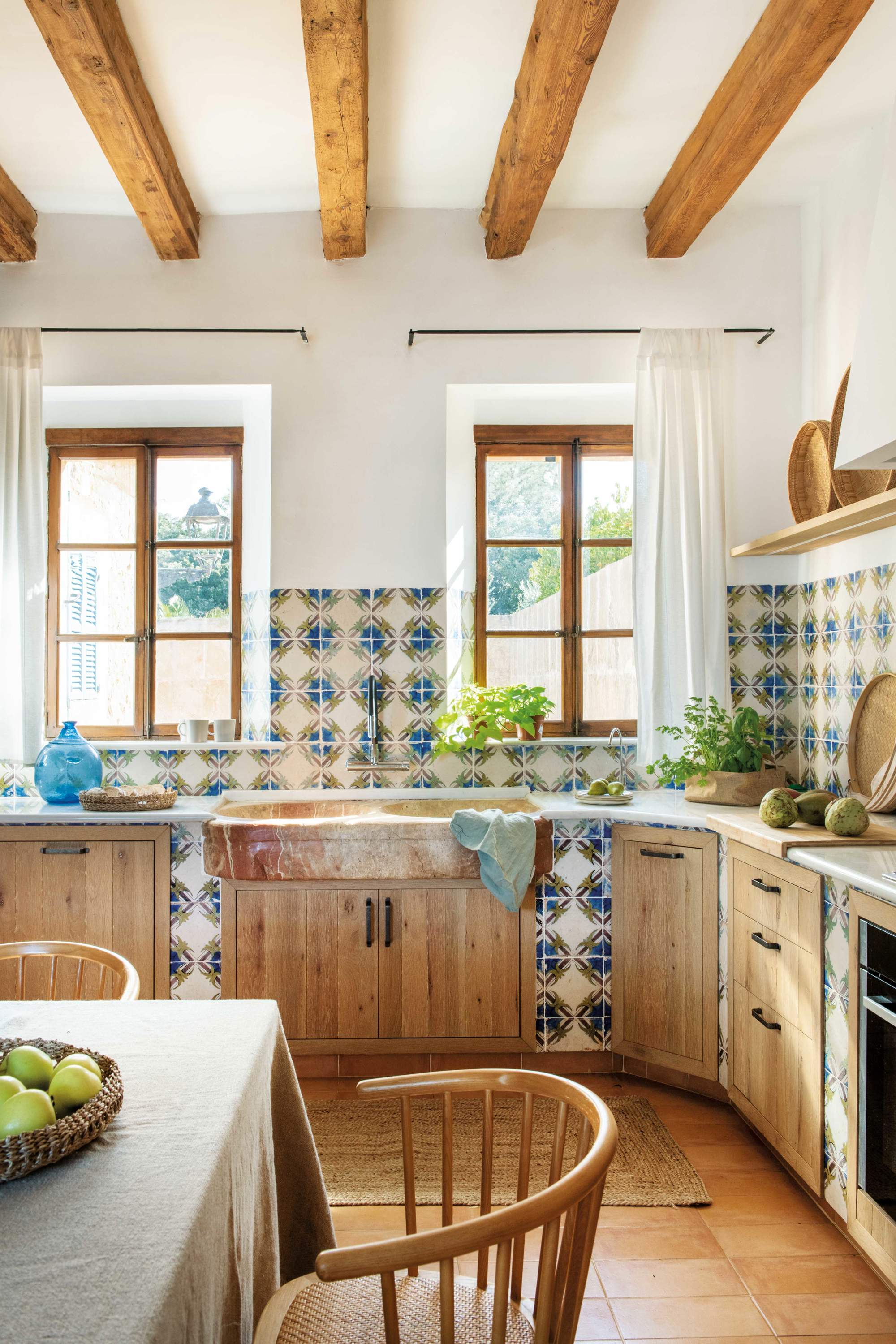Cocina rústica con frentes de madera, vigas, azulejos estampados y office
