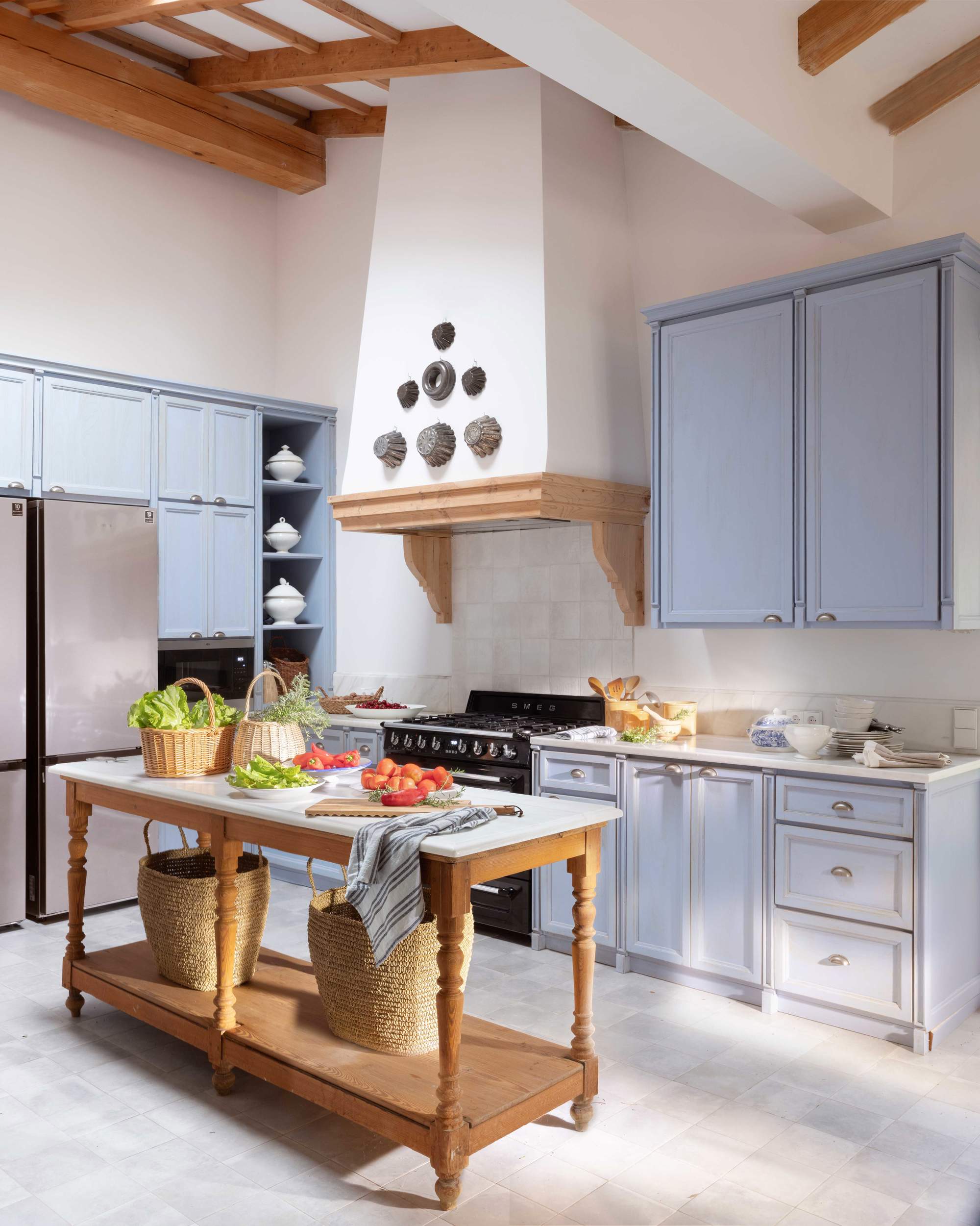 Cocina rústica con muebles en tono añil y mesa de madera con patas torneadas