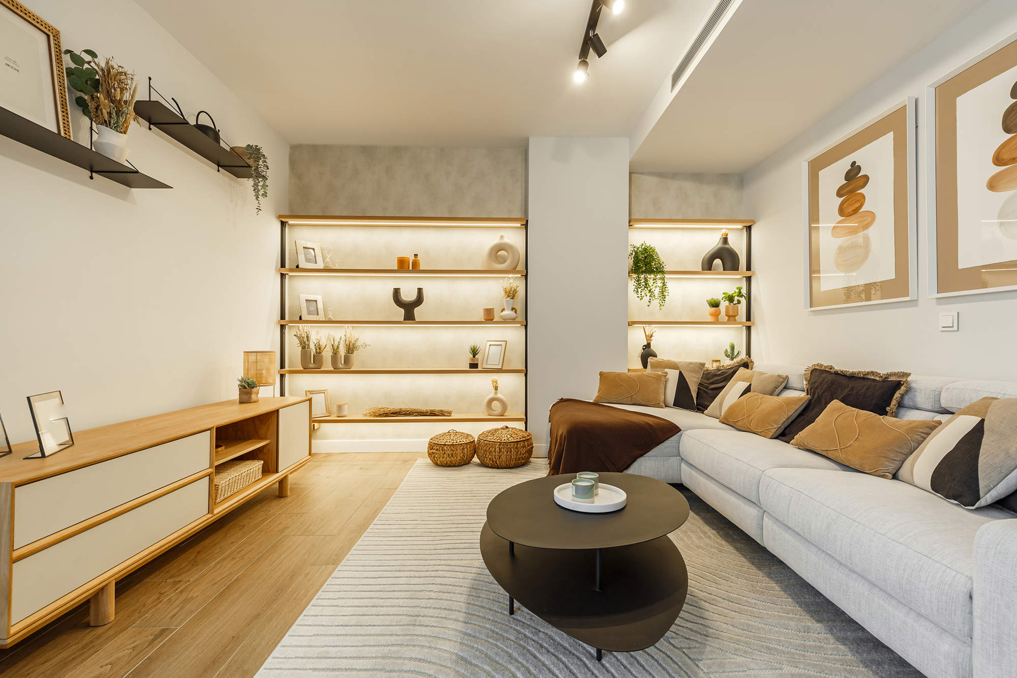 Salón con sofá gris, mesas nido, mueble de TV de madera y estantería a medida