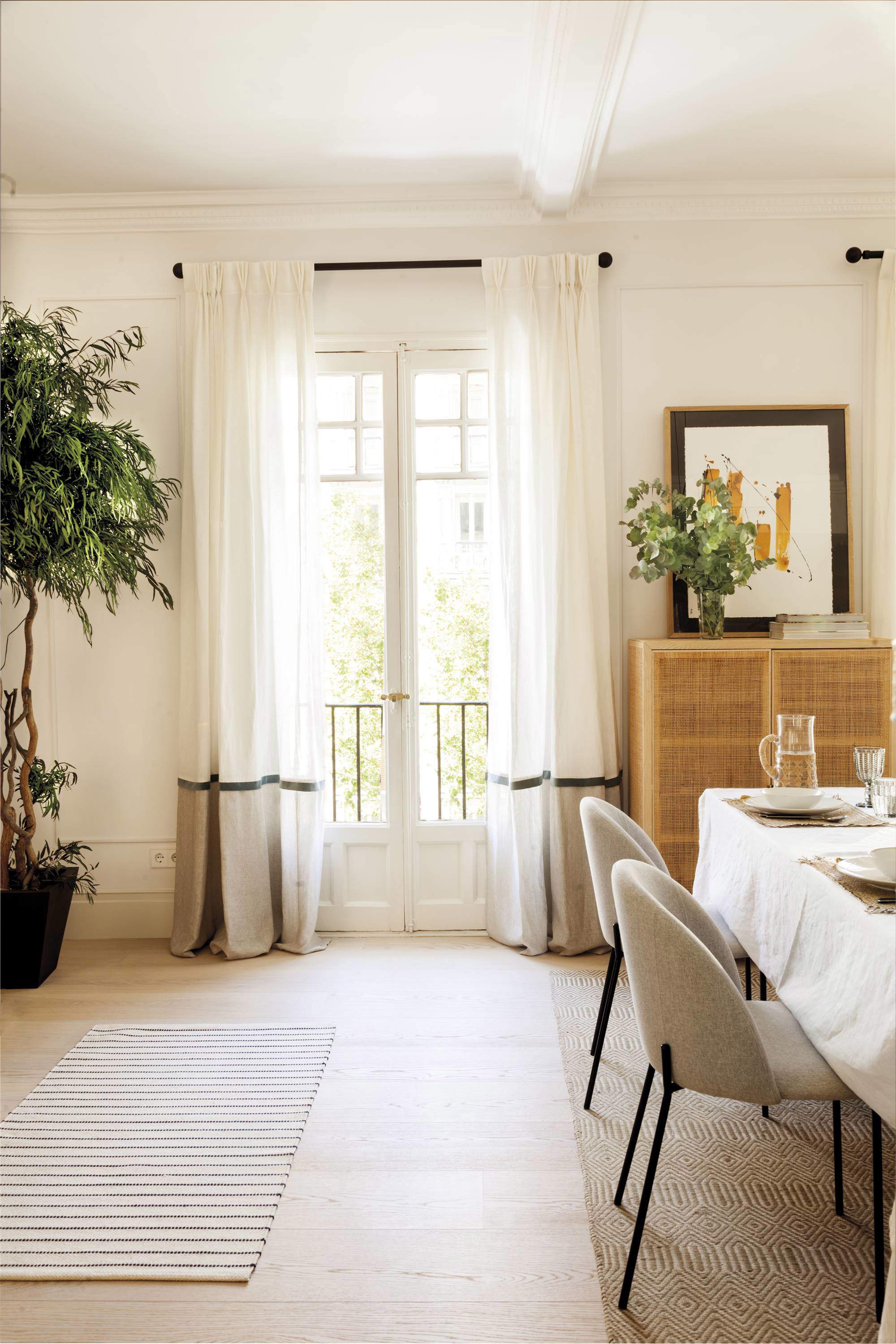 Salón comedor con ventanal con cortinas blancas con faldón