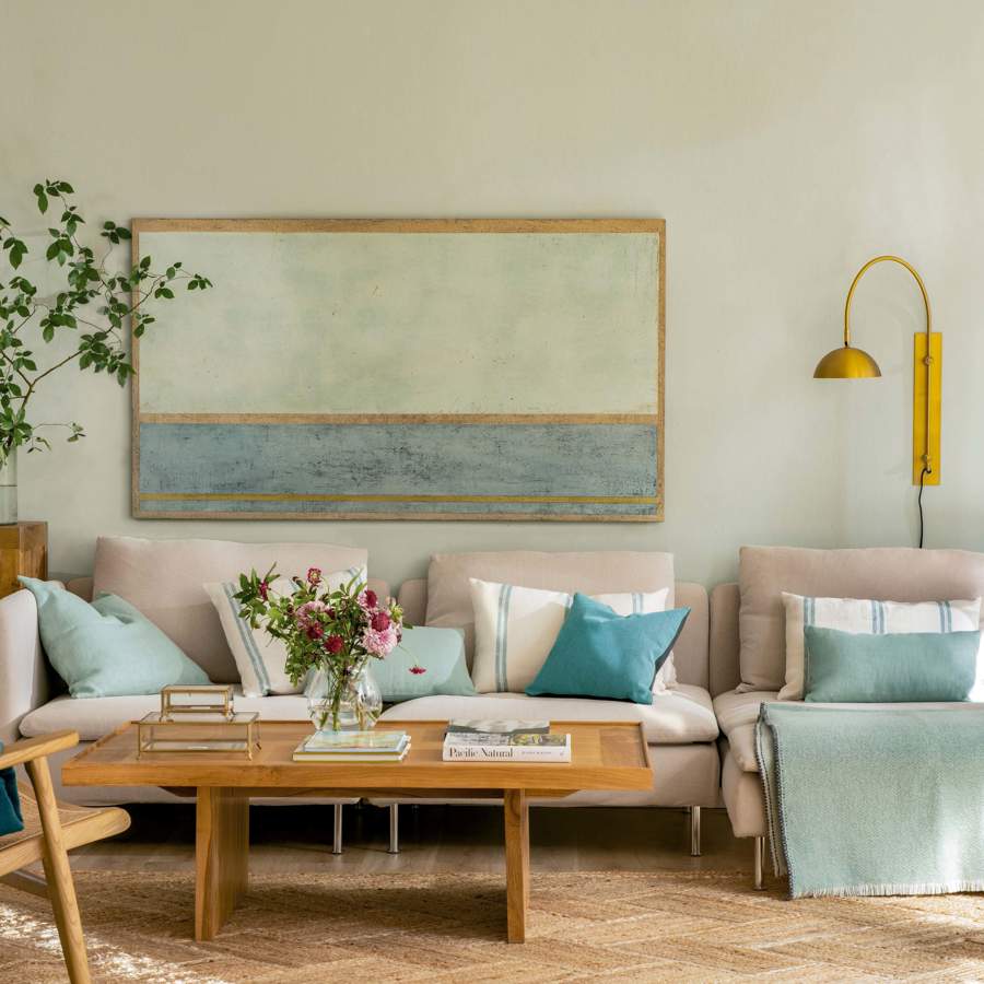 Salón con sofá modular y cuadro azul y verde.