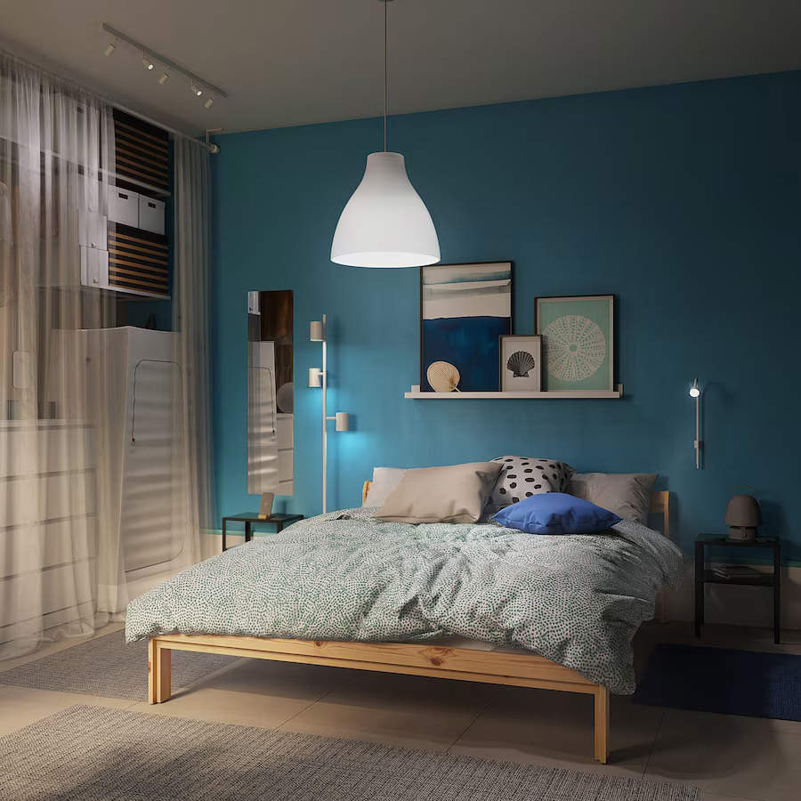 Dormitorio con pared azul, cama de madera y armario con cortinas