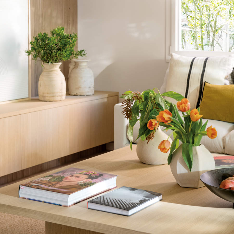 Salón elegante y cálido con mesa de centro de madera natural y flores