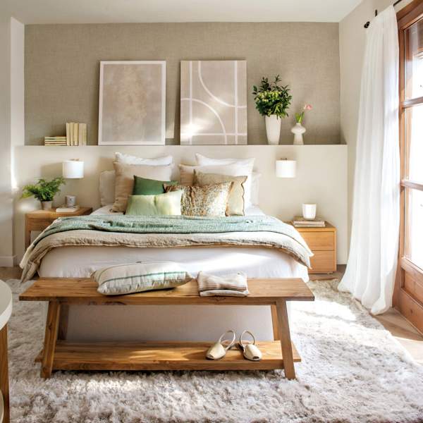 Dormitorio pequeño con cabecero de obra, banco a los pies y cuadros
