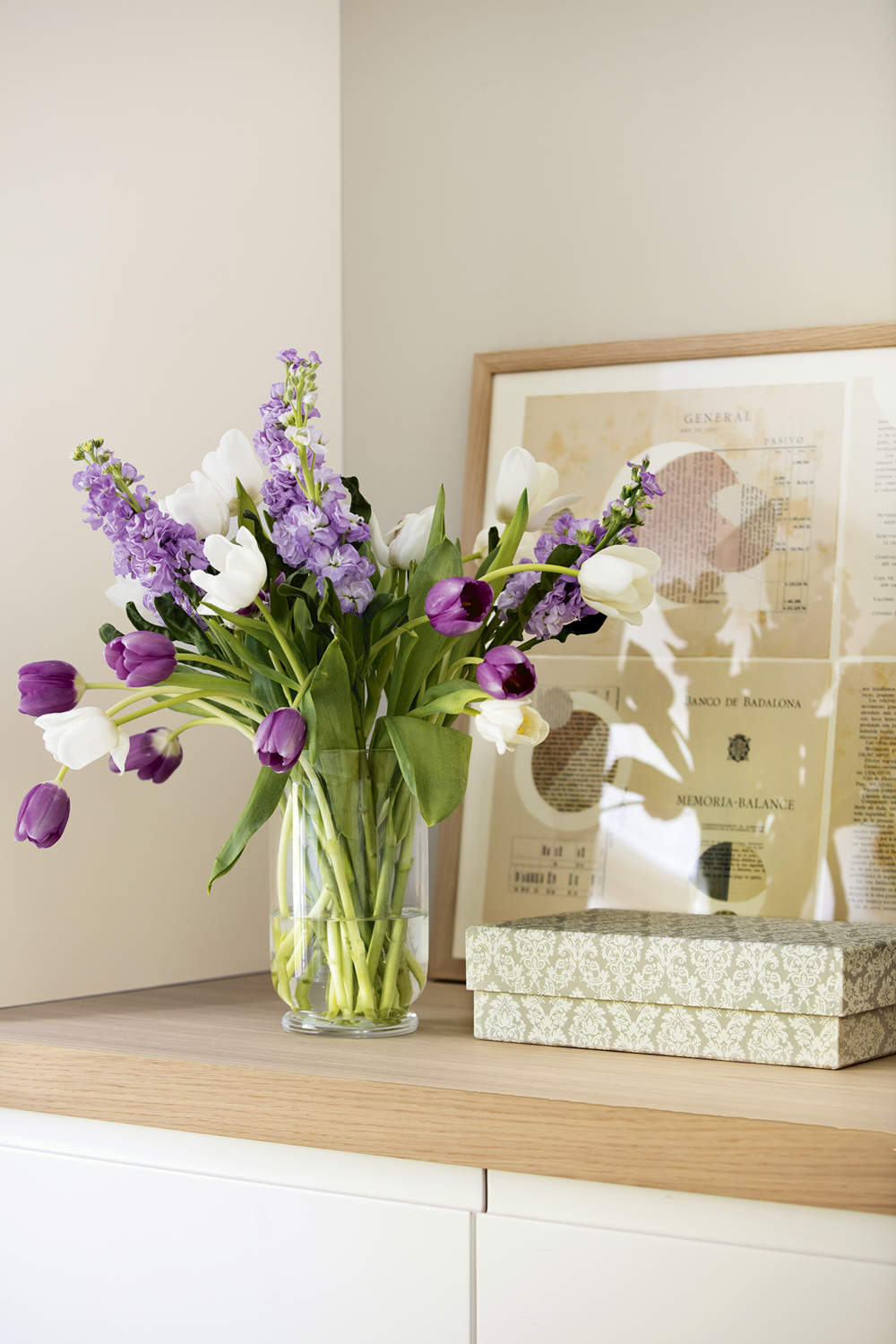 Tulipanes violeta en florero de cristal decorando el cabecero