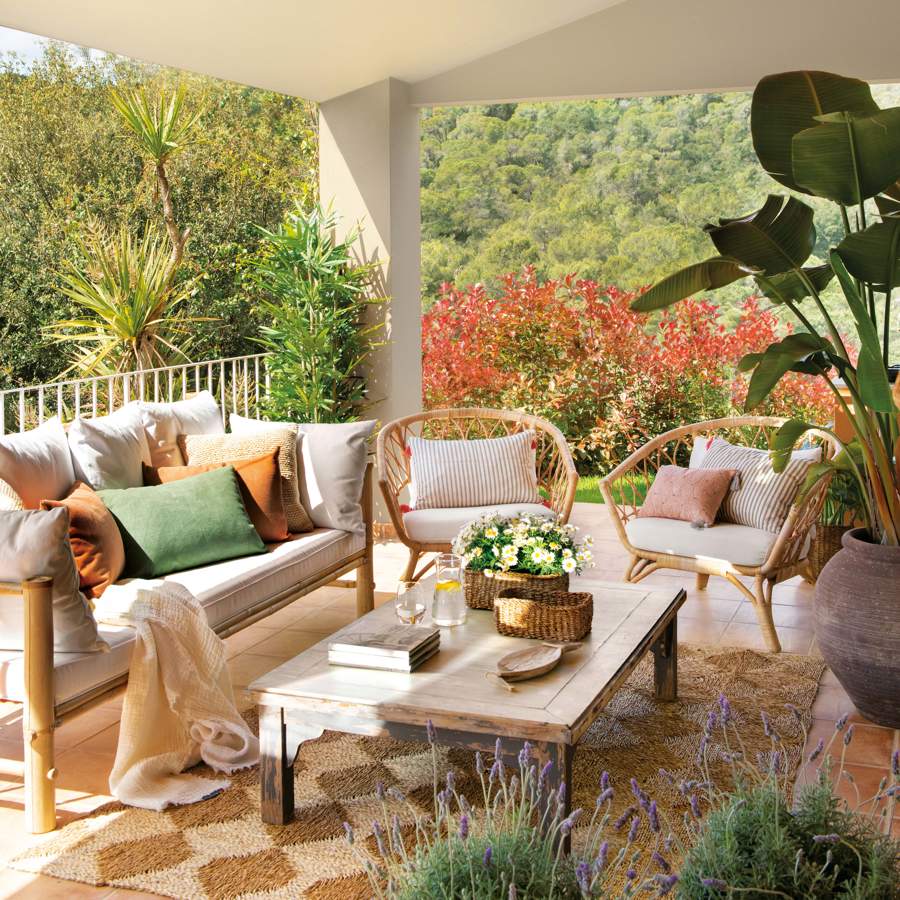 Terraza con muebles de fibra natural, mesa de madera y alfombra de fibra geométrica
