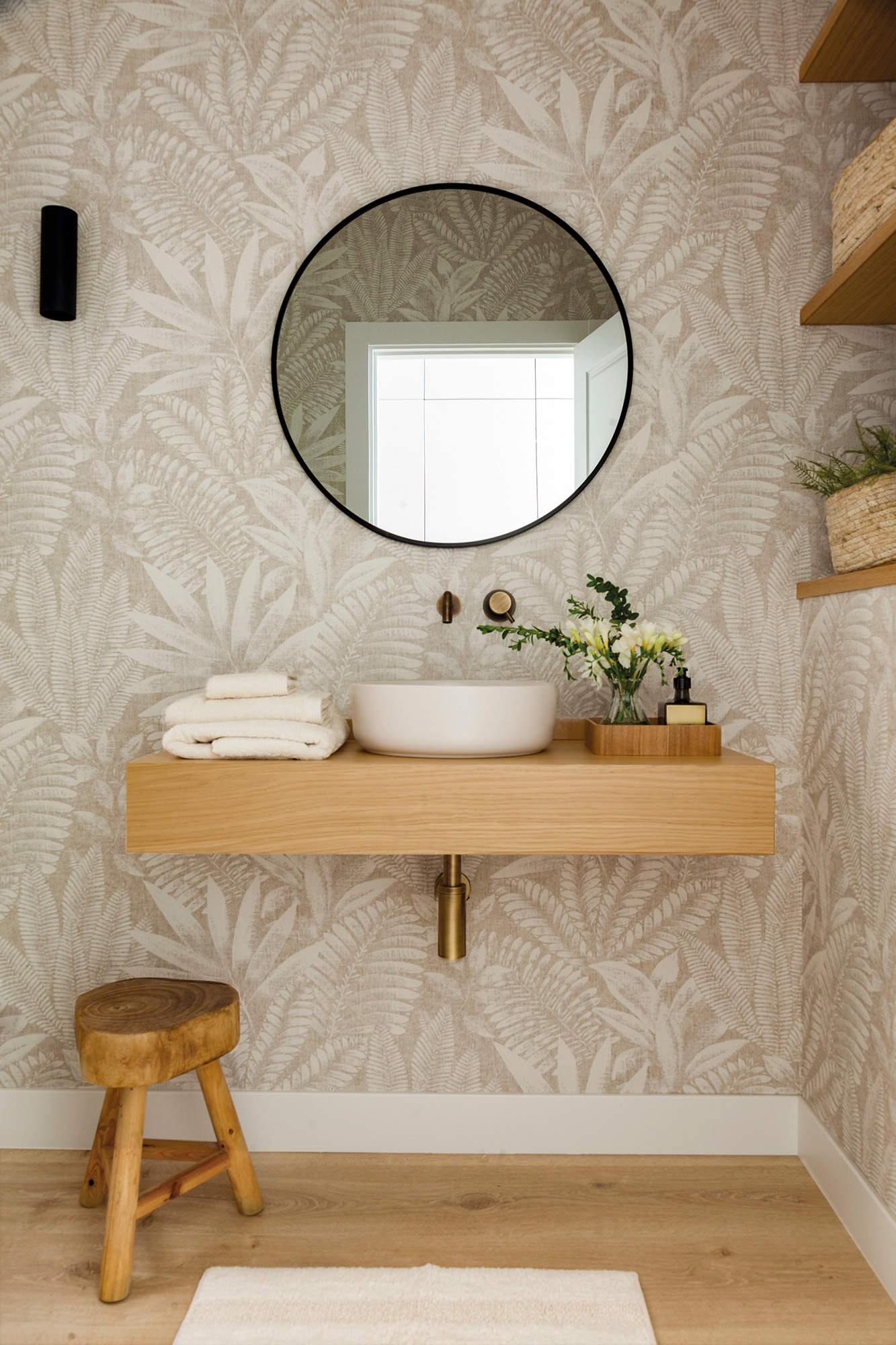 Baño mini decorado con papel pintado en las paredes.