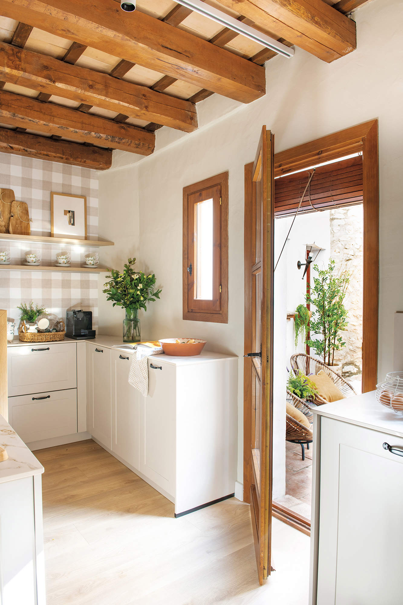 Cocina mini con muebles blancos y estantes en madera en la pared