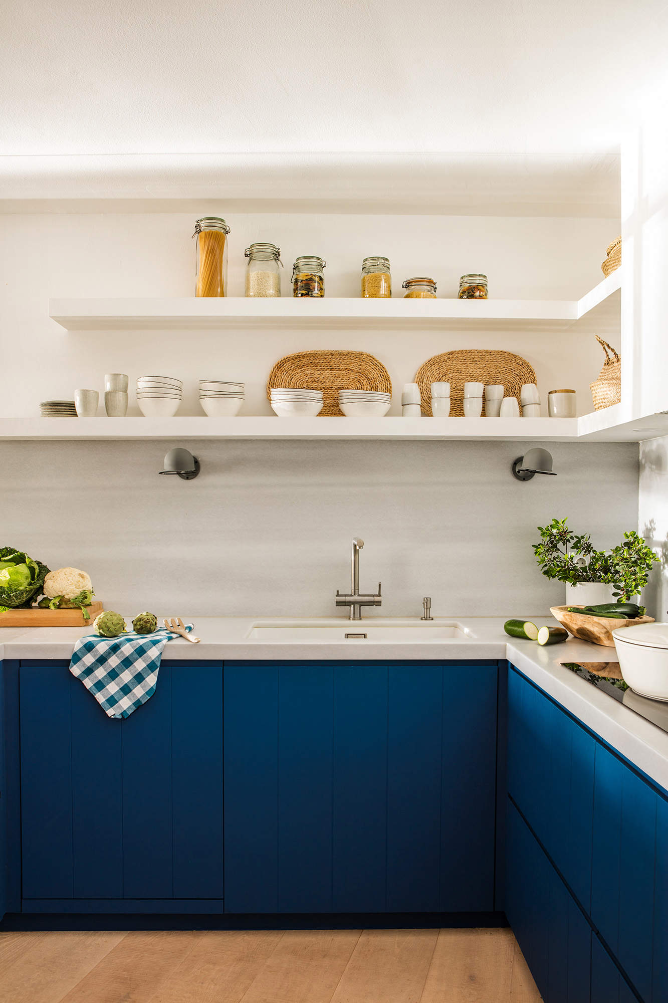 Cocina con muebles en azul y estantes en blanco