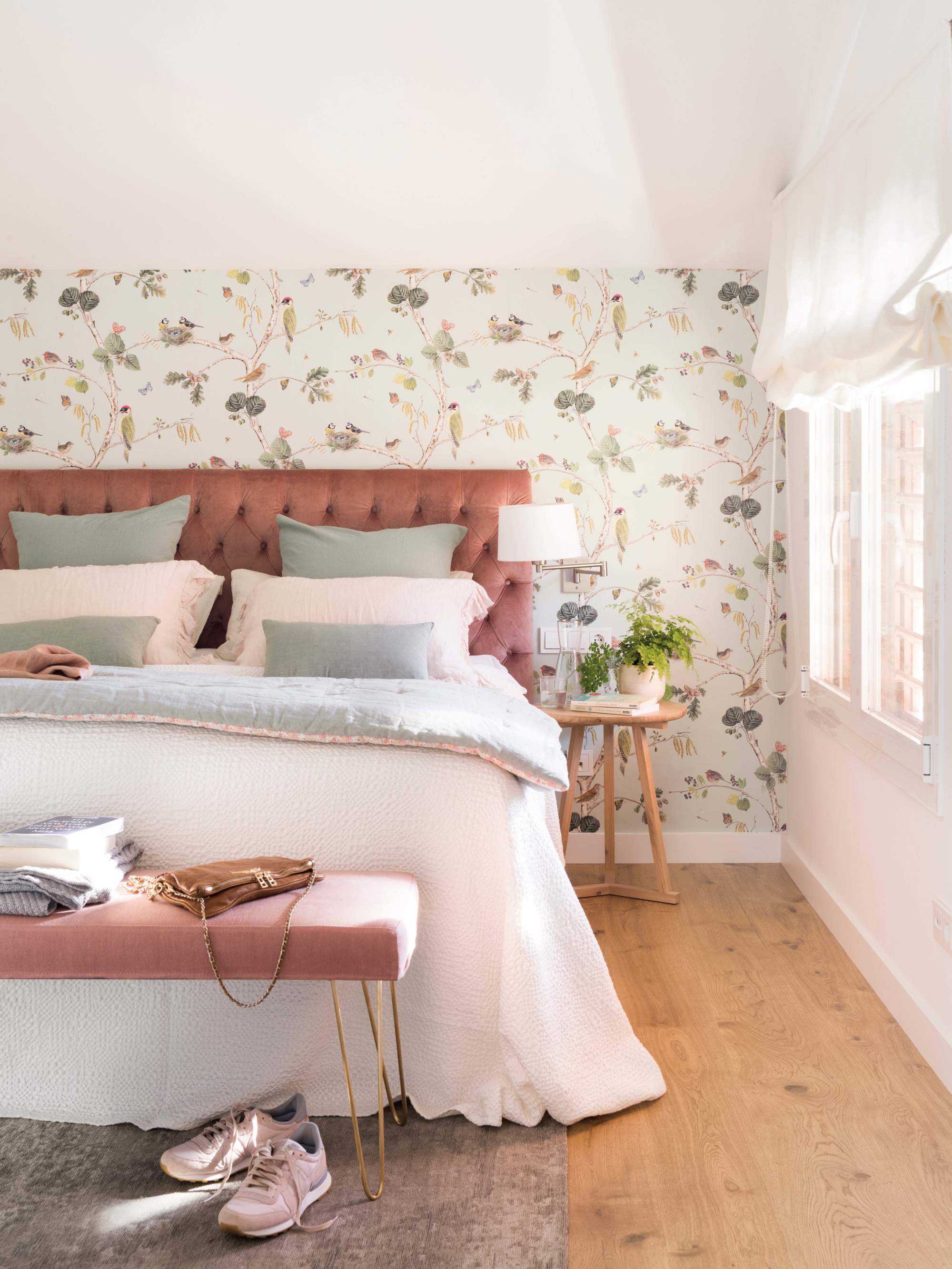 Dormitorio con cabecero tapizado en rosa y papel pintado
