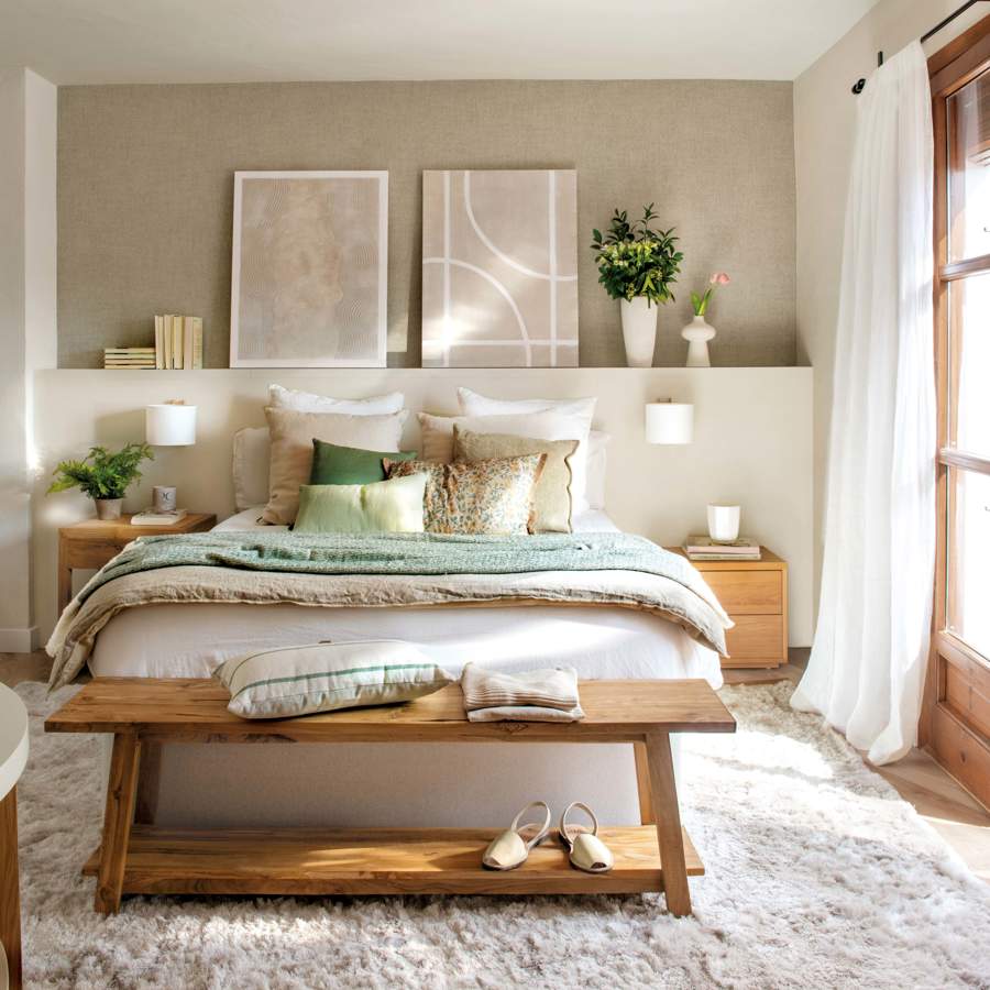 Dormitorio pequeño con cabecero de obra, banco a los pies y cuadros