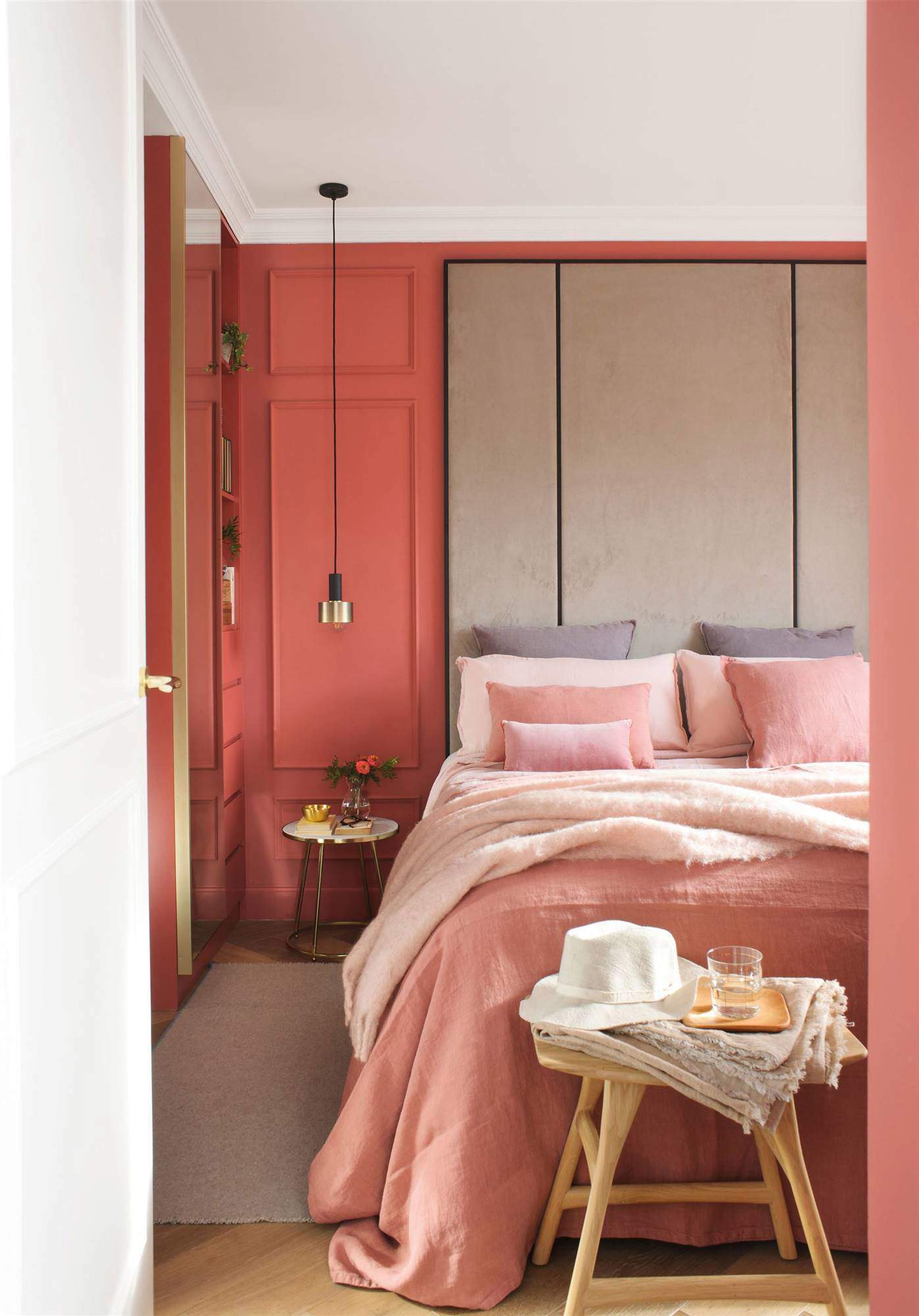 Dormitorio romántico con cabecero XL de terciopelo gris y paredes con molduras pintadas en rosa intenso