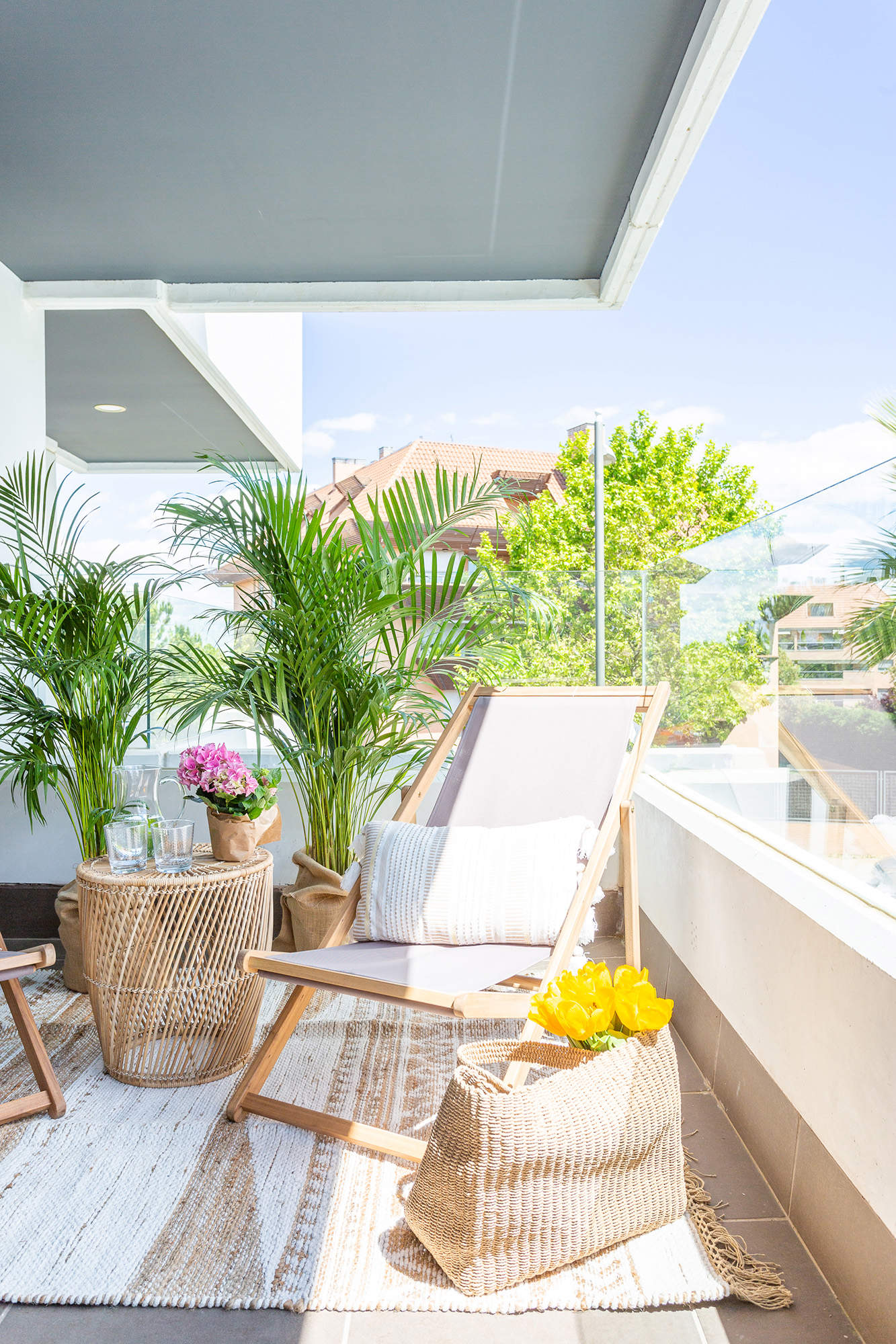 Terraza pequeña decorada con tumbonas plegables