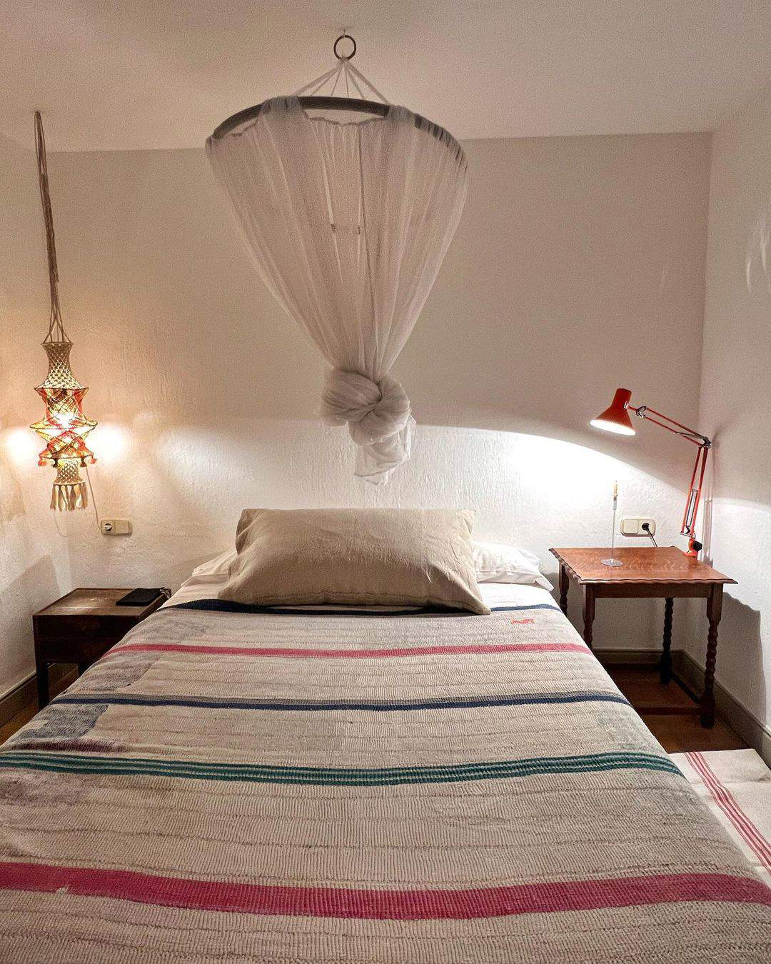 Dormitorio rústico con dosel y colcha de lino