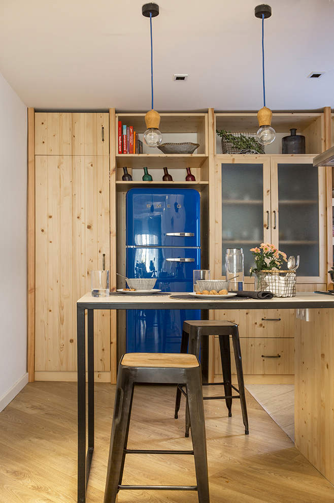 cocina de madera con nevera azul de Smeg.