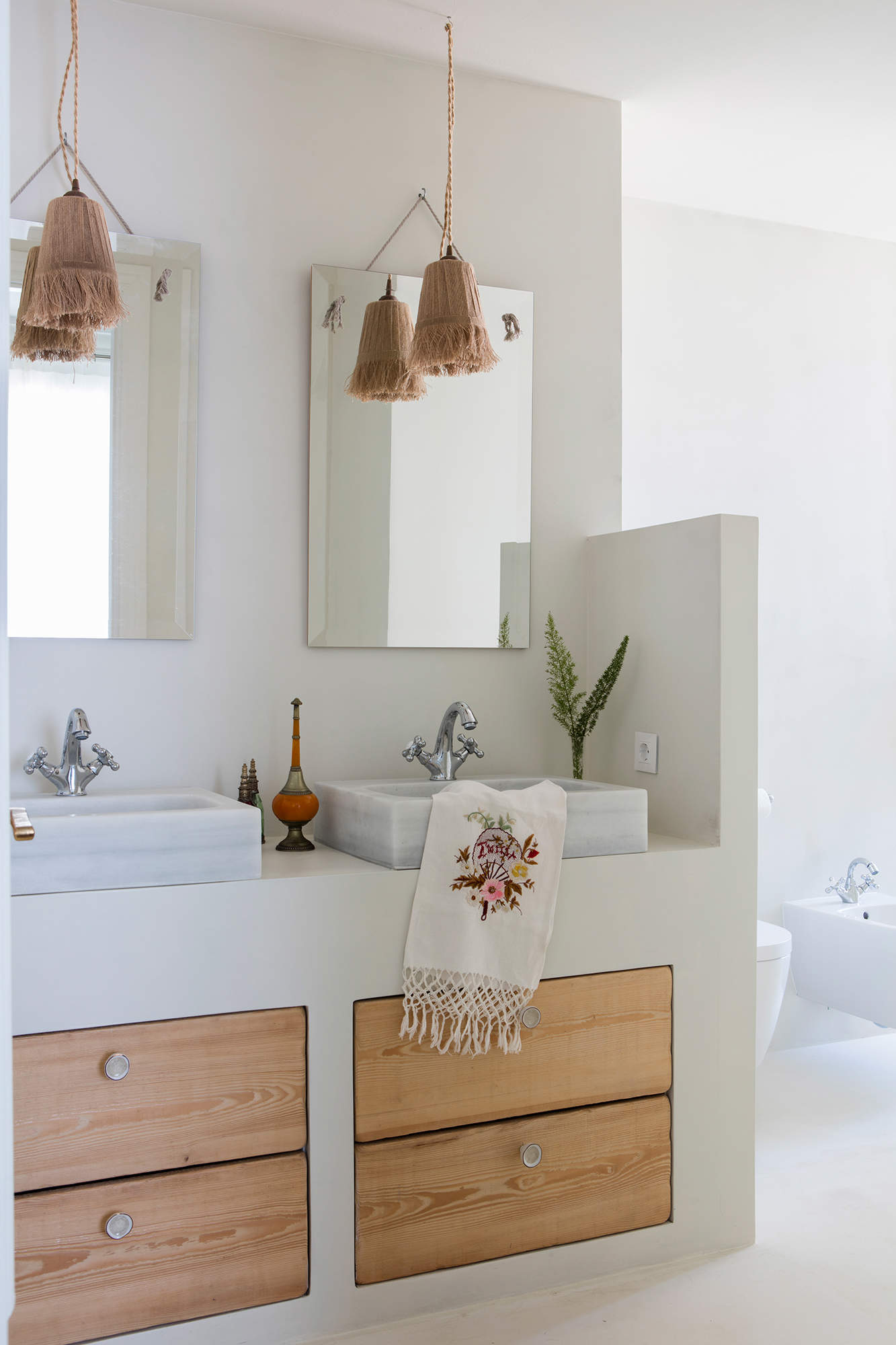 Baño con mueble de obra, espejos y lámparas suspendidas de fibra