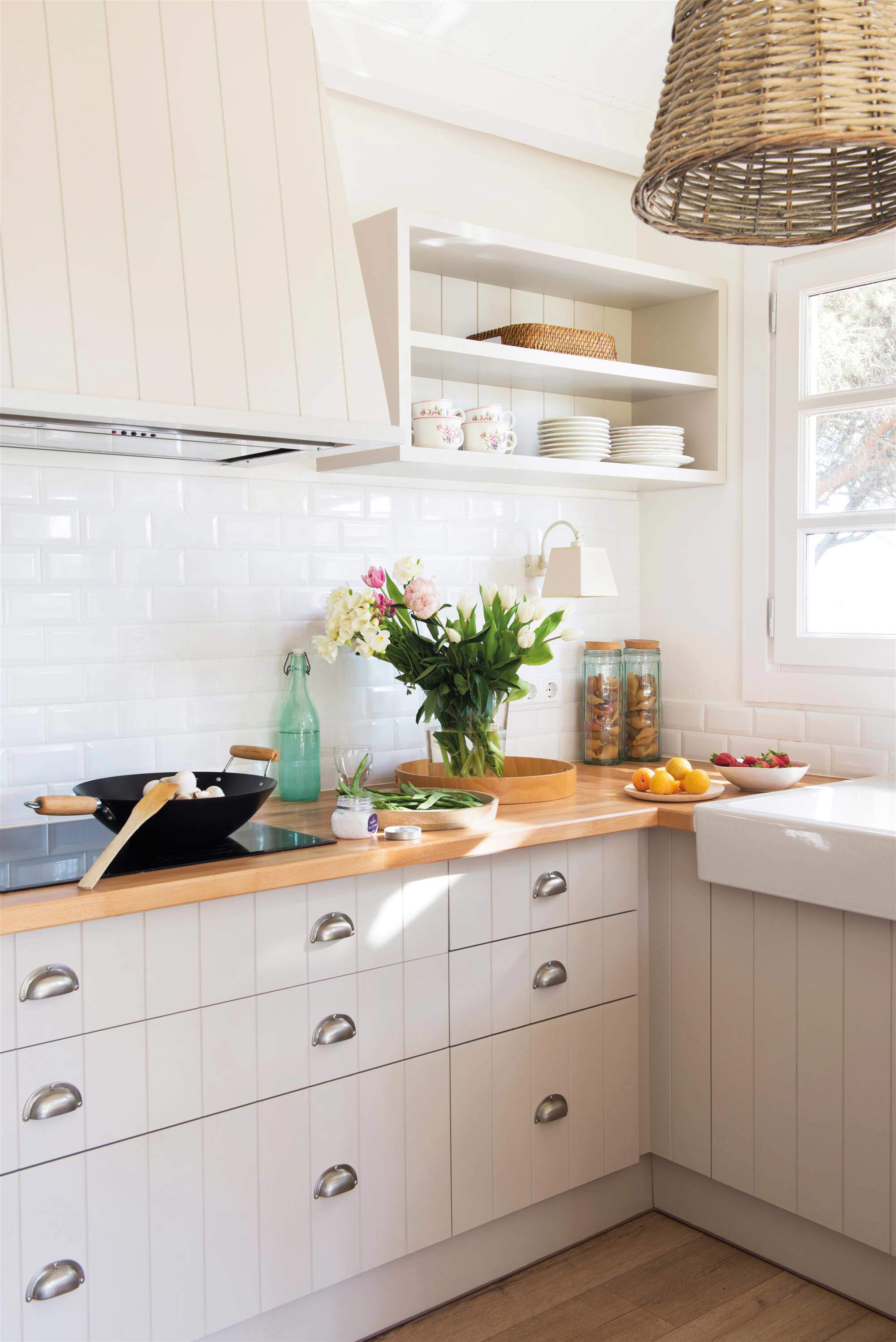 Cocina blanca con muebles alistonados, campana forrada y encimera de madera