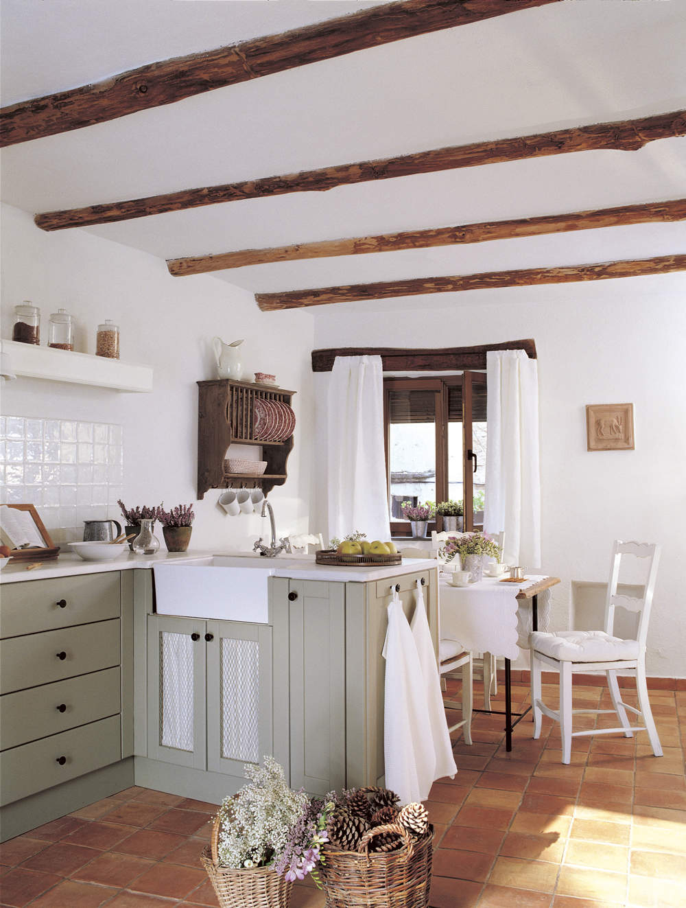 Cocina de estilo rústico con vigas de madera, mobiliario diseñado a medida en color verde y platero de madera