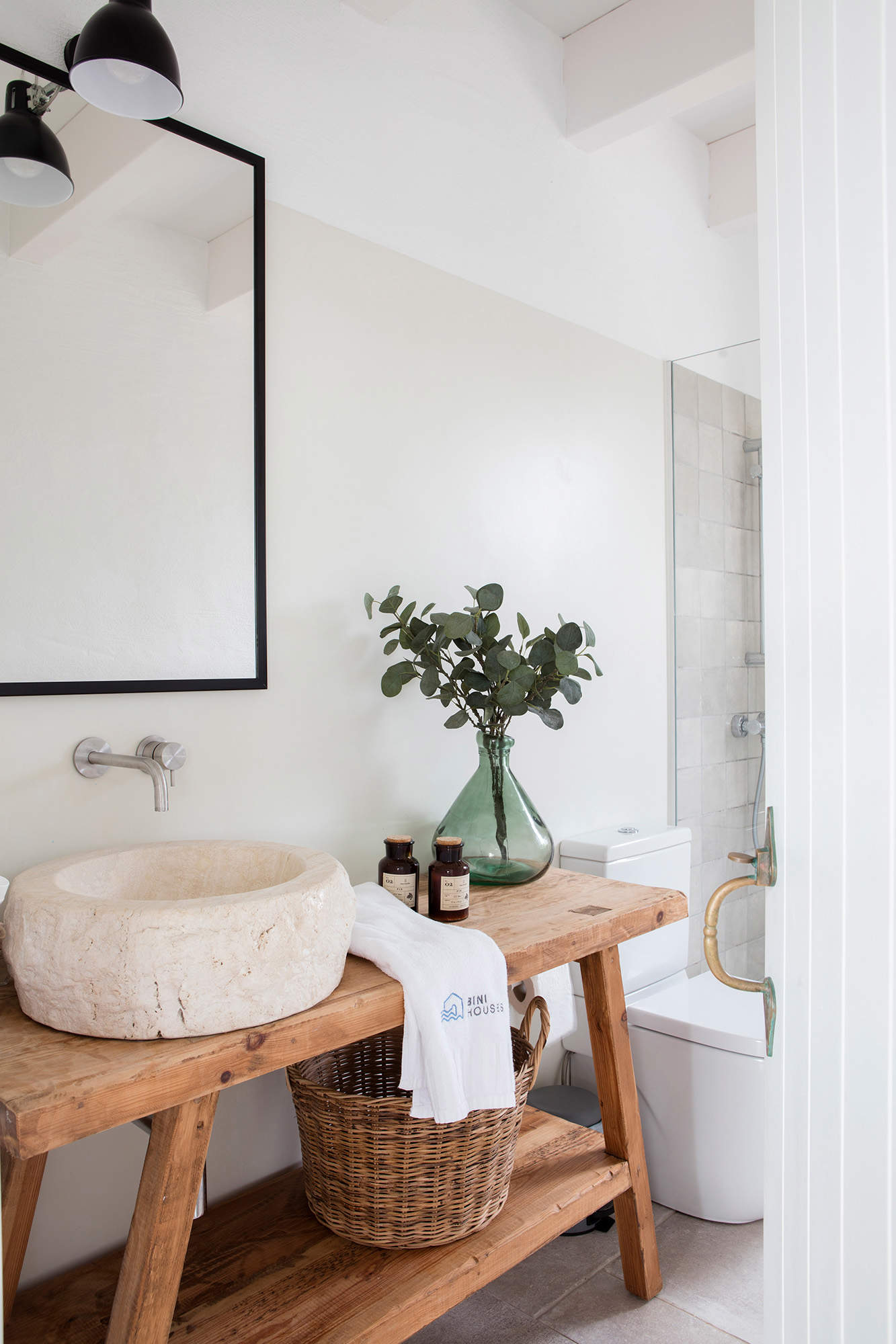 Detalle de frente de lavabo con mueble de madera y lavabo de piedra