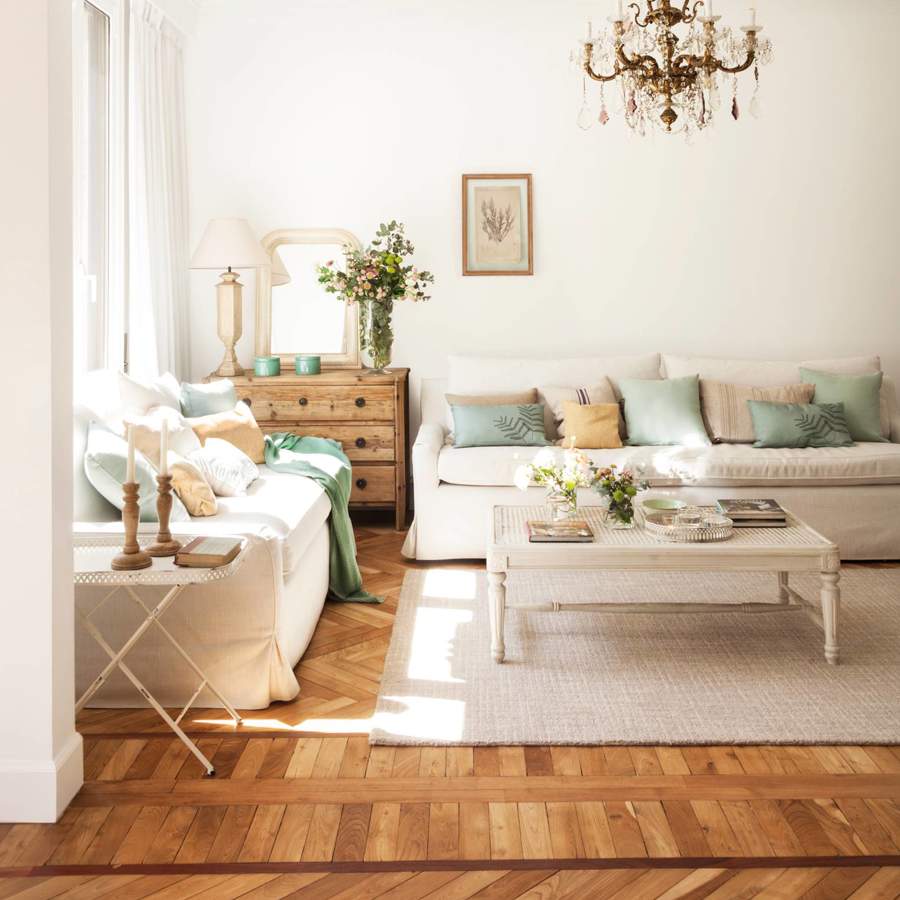 Salón con distintos tipos de parquet sofás blancos comoda madera y lámpara techo araña_458380