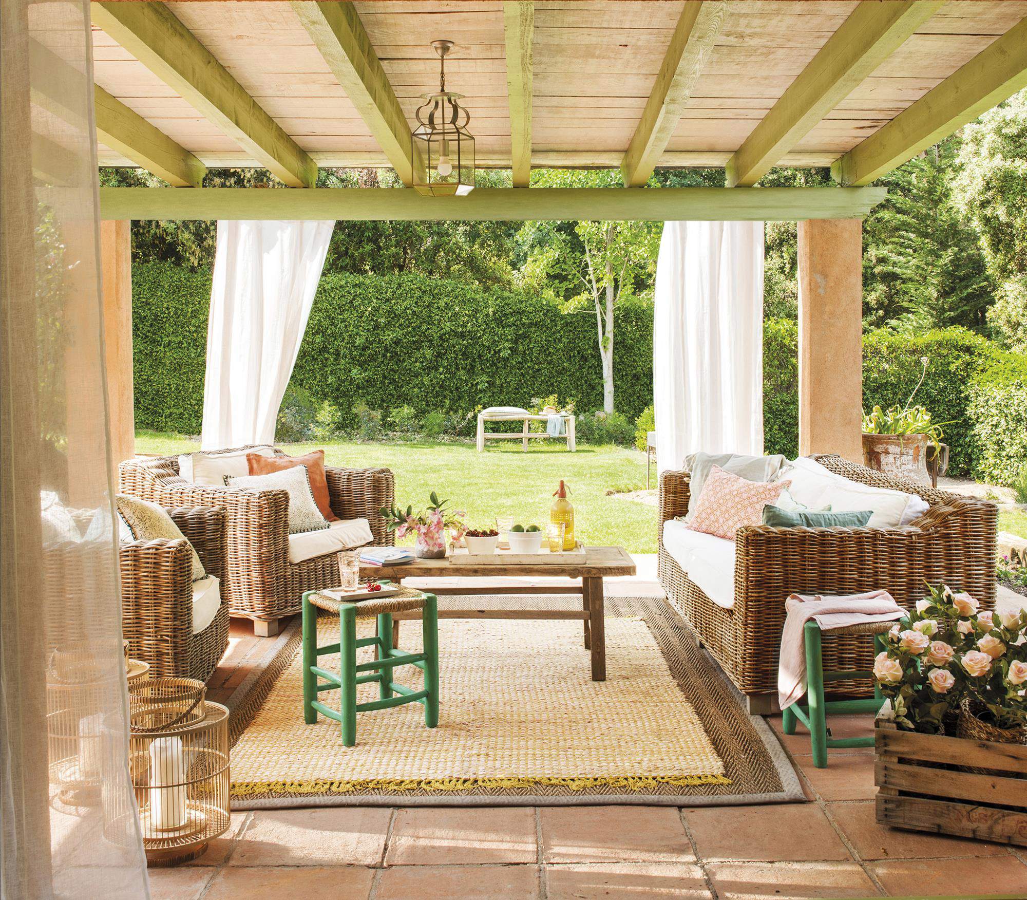 Salón de verano decorado con asientos de fibra y una mesa de centro de madera natural.