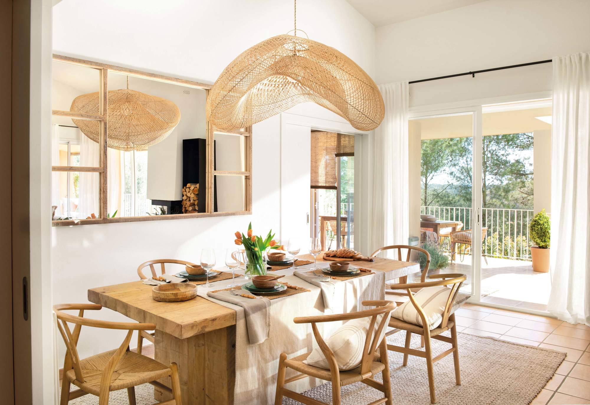 Comedor con mesa de madera, sillas de diseño y lámpara de fibra