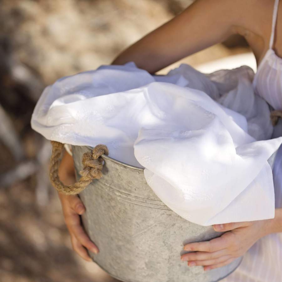 mujer sosteniendo un barreno con ropa blanca 