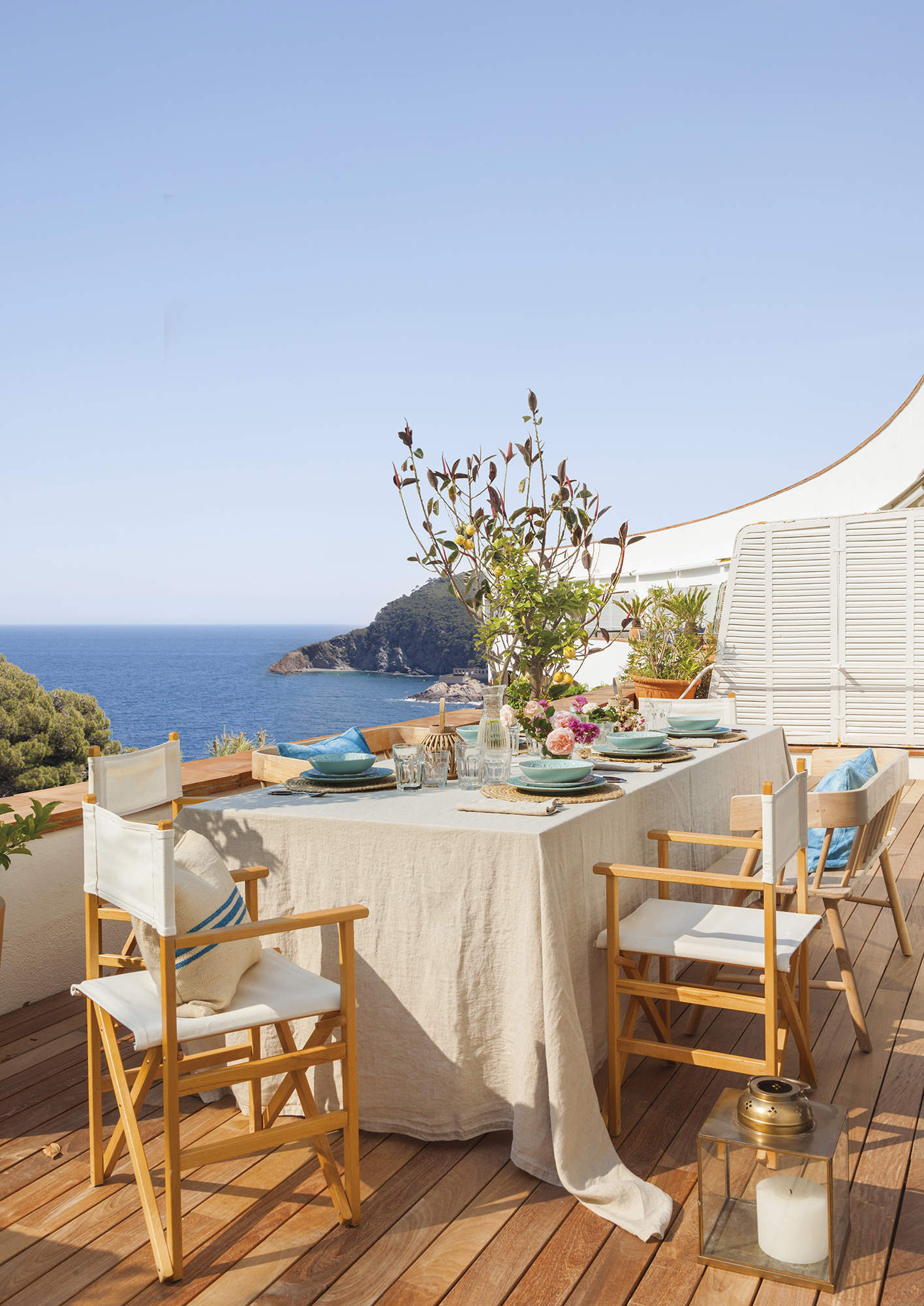 Terraza con vistas al mar decorada con sillas de madera.