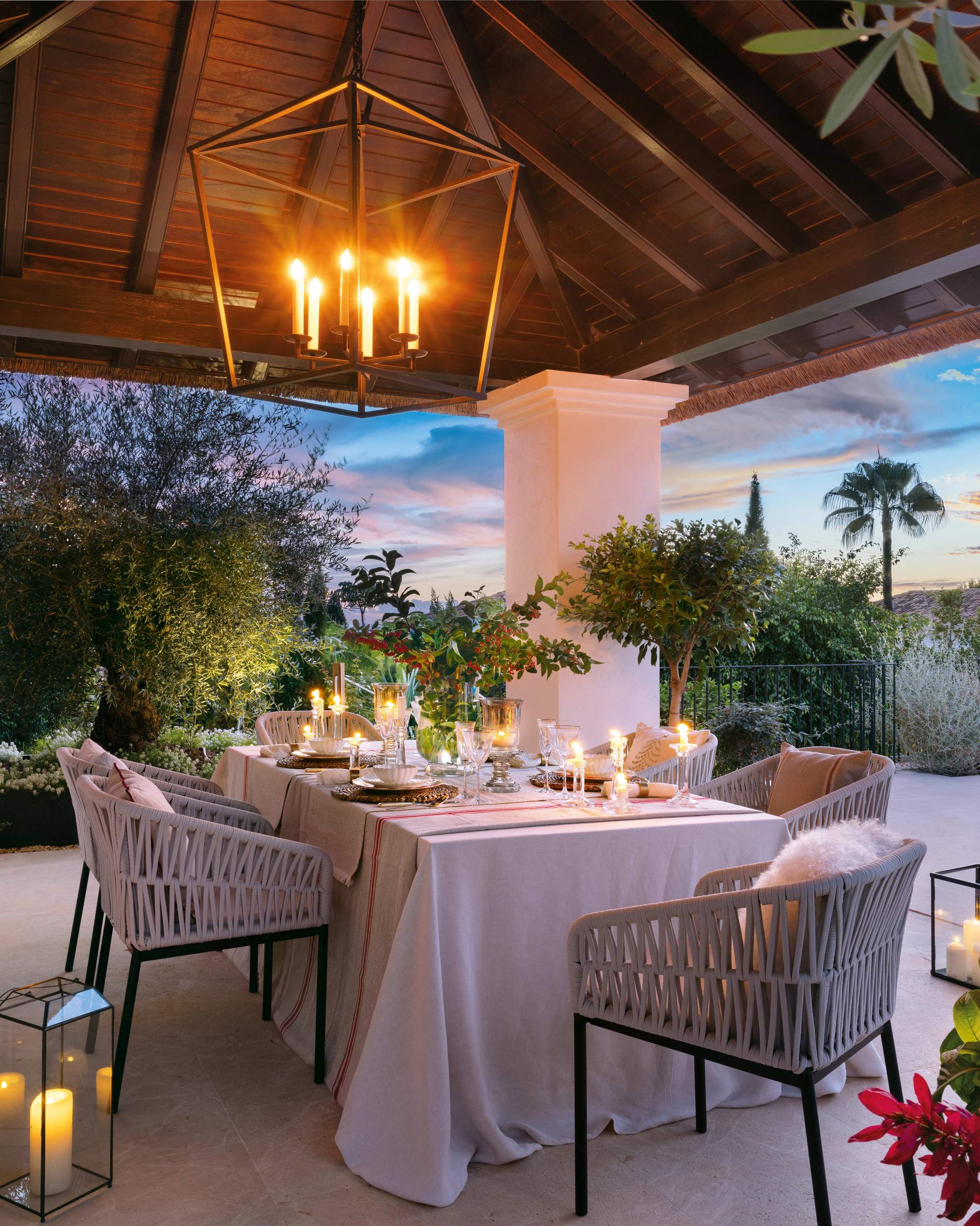 Comedor exterior bajo pérgola por la noche