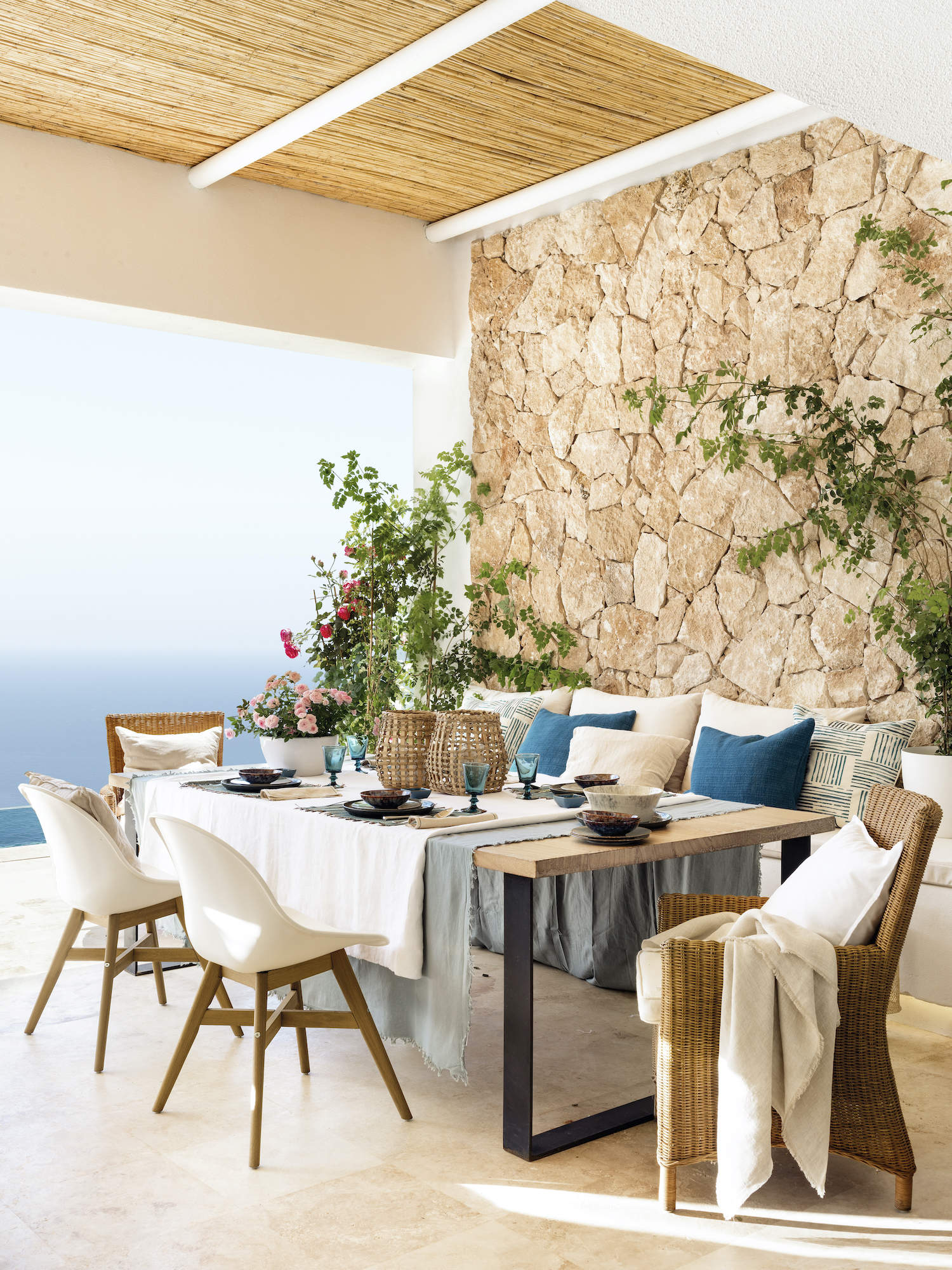 Comedor exterior con pared de piedra y vistas al mar 00558461