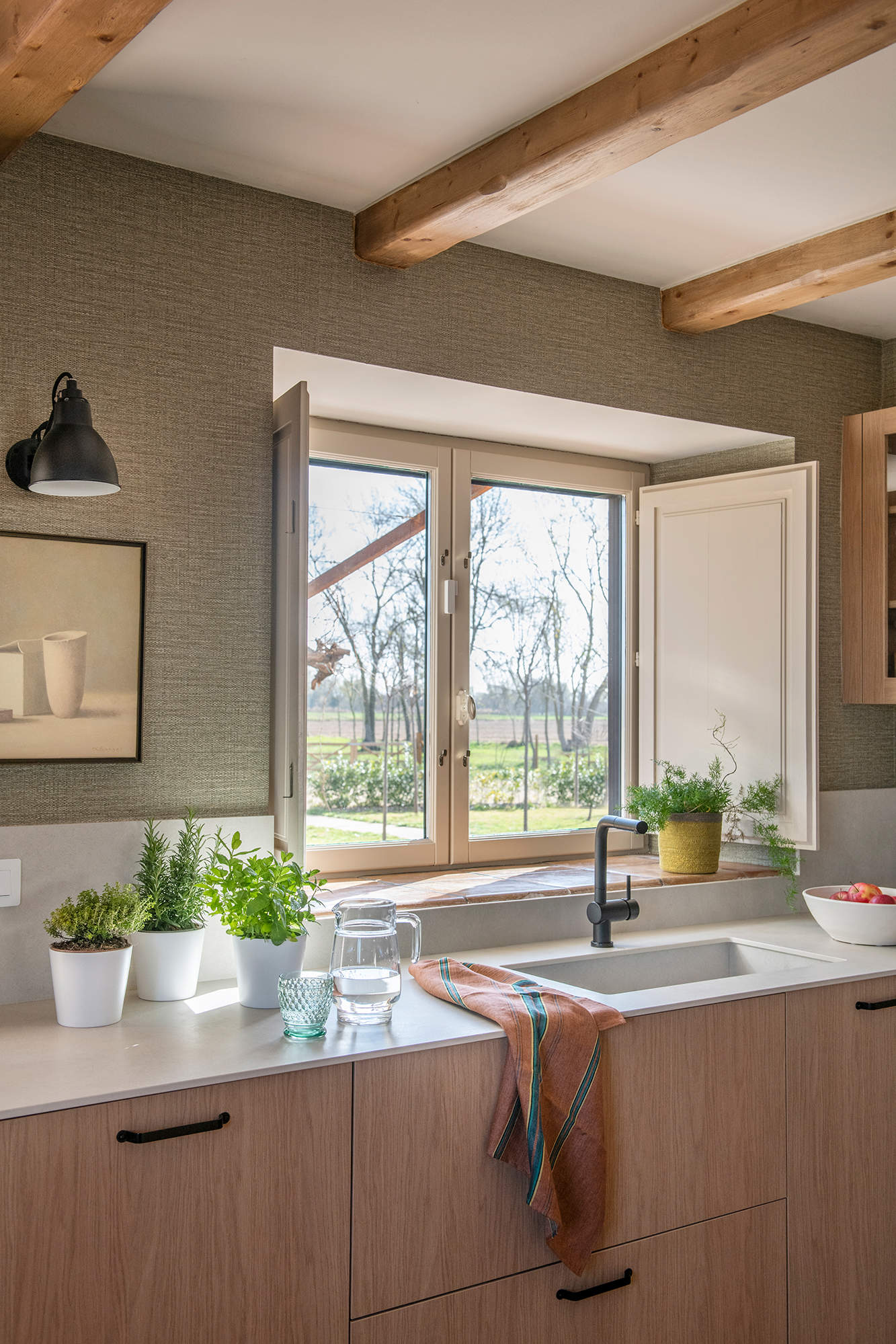 Cocina con papel pintado y encimera blanca. 