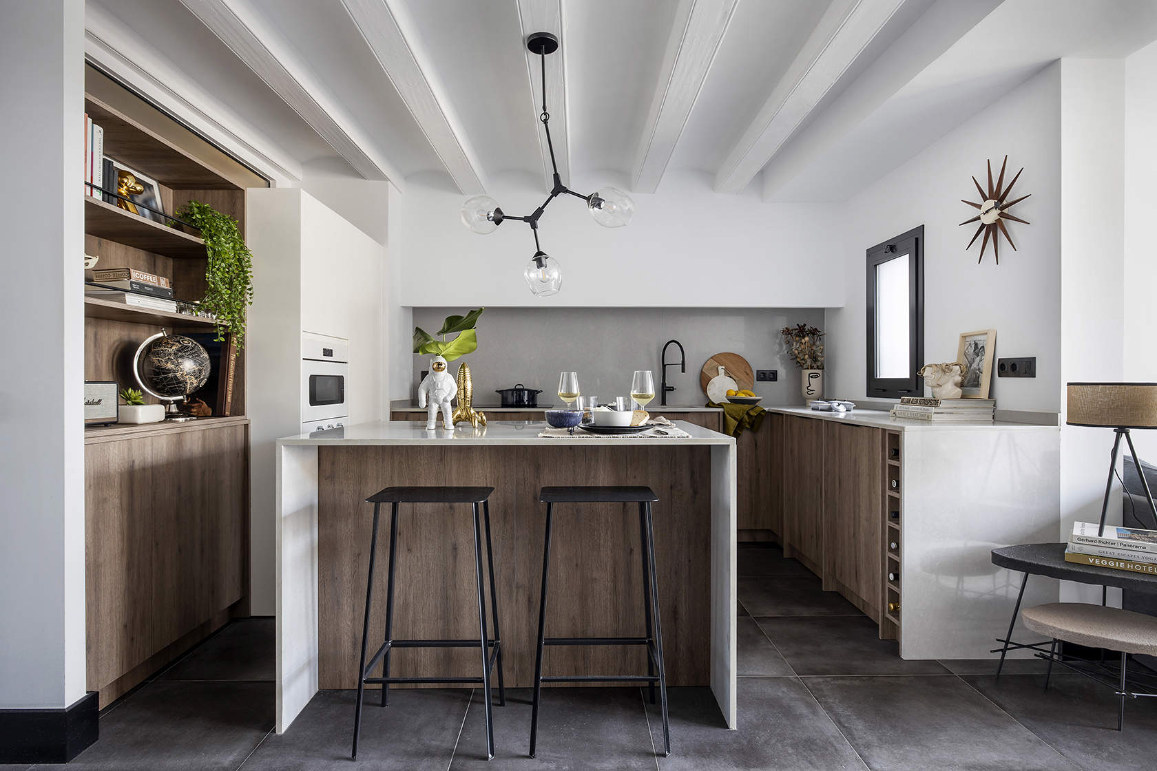 Cocina de madera con vigas lacadas de blanco y lámpara suspendida