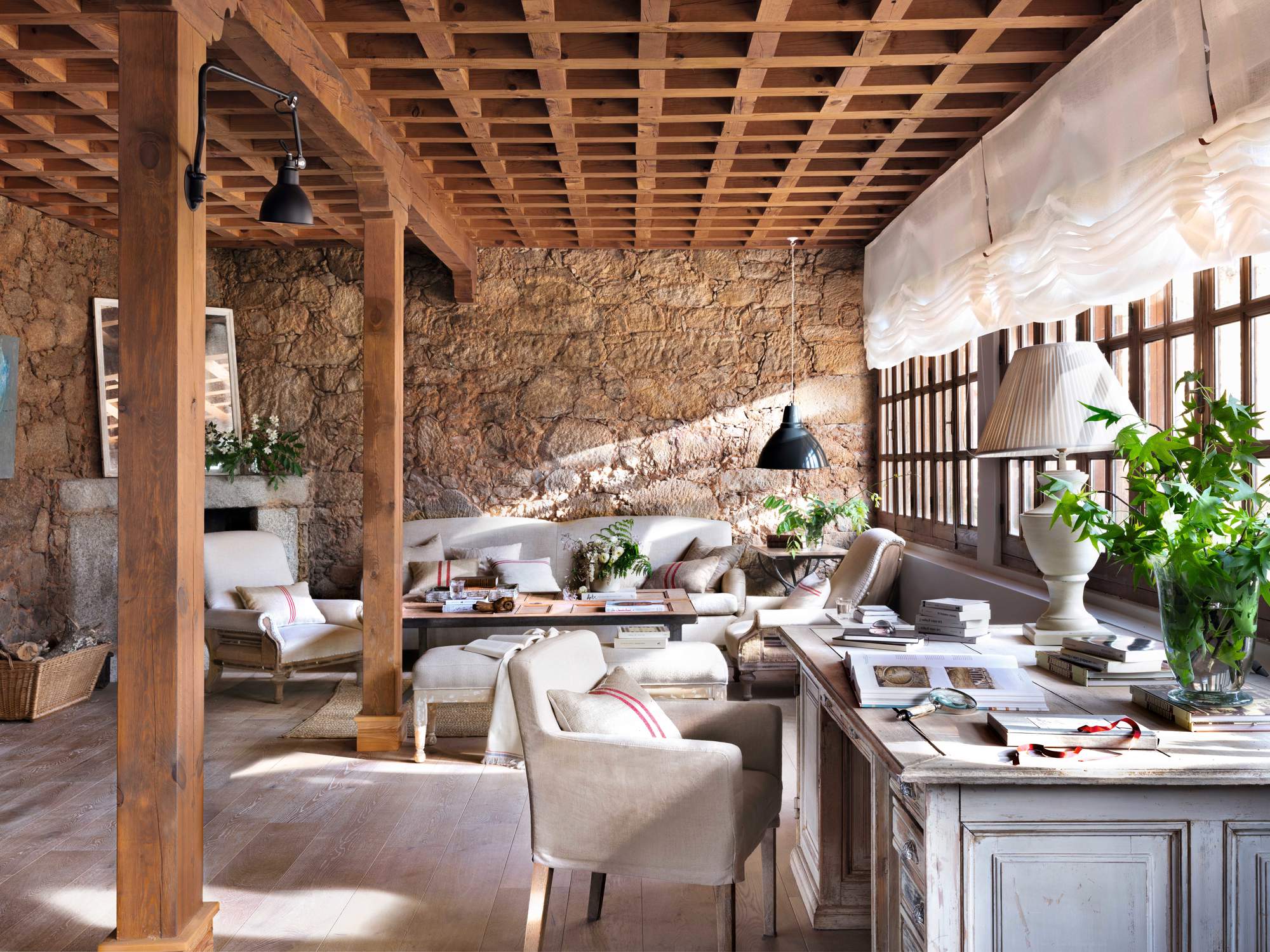 Salón con pared de piedra y techo artesonado