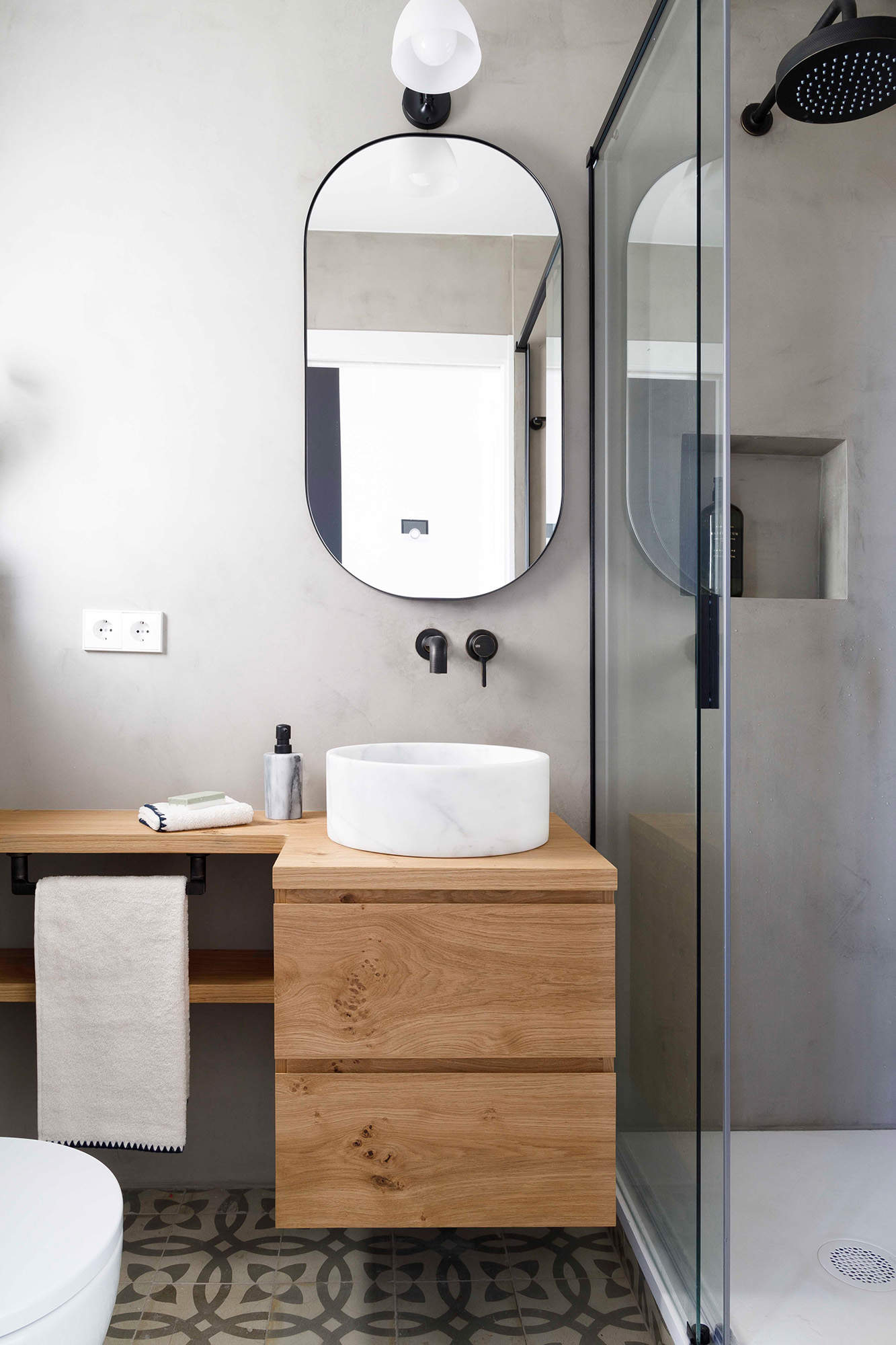 Baño pequeño con ducha y grifería empotrada en el lavabo y en la ducha.