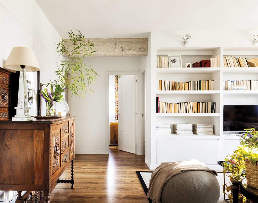 Salón con librería blanca y mueble de anticuario