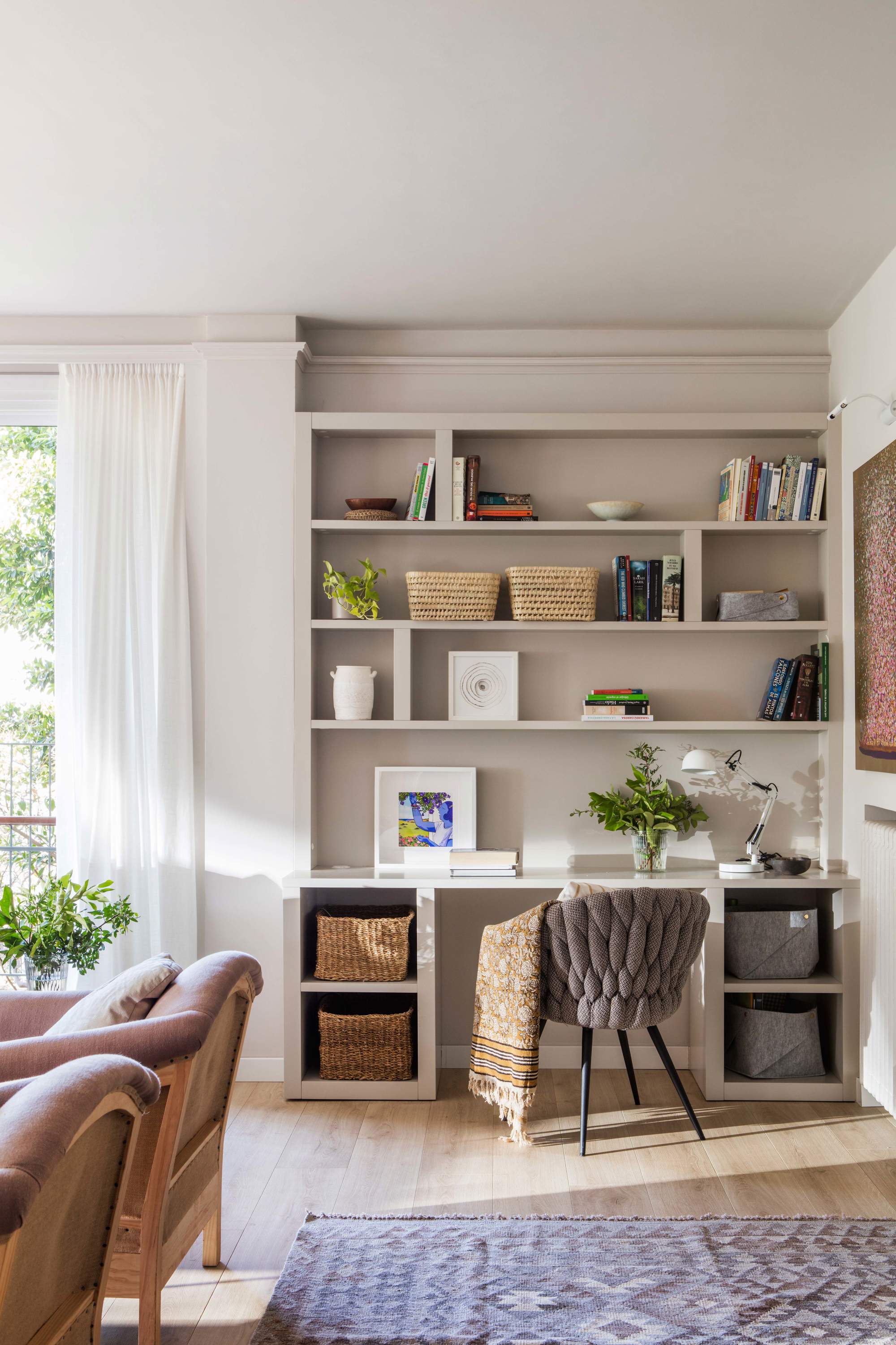 Salón con estantería de obra y escritorio.