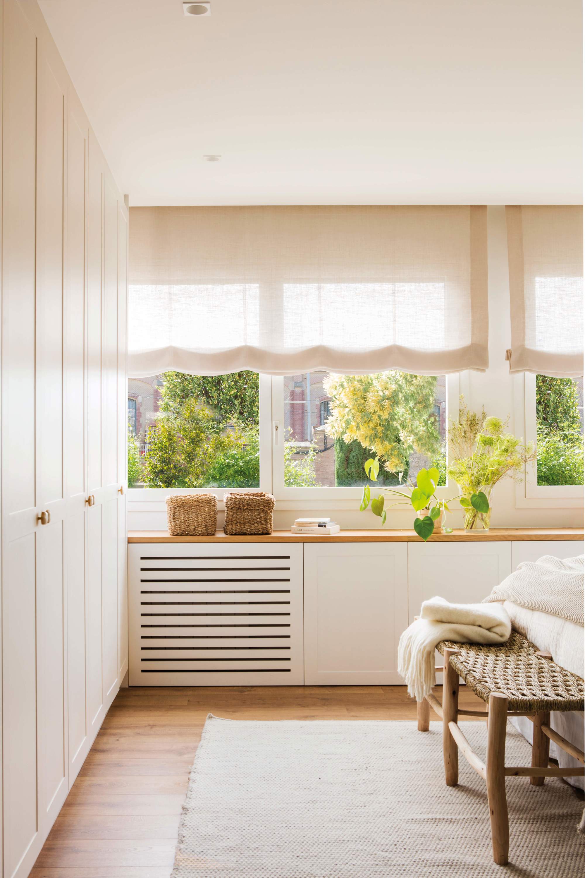 Dormitorio pequeño con mueble zapatero bajo la ventana