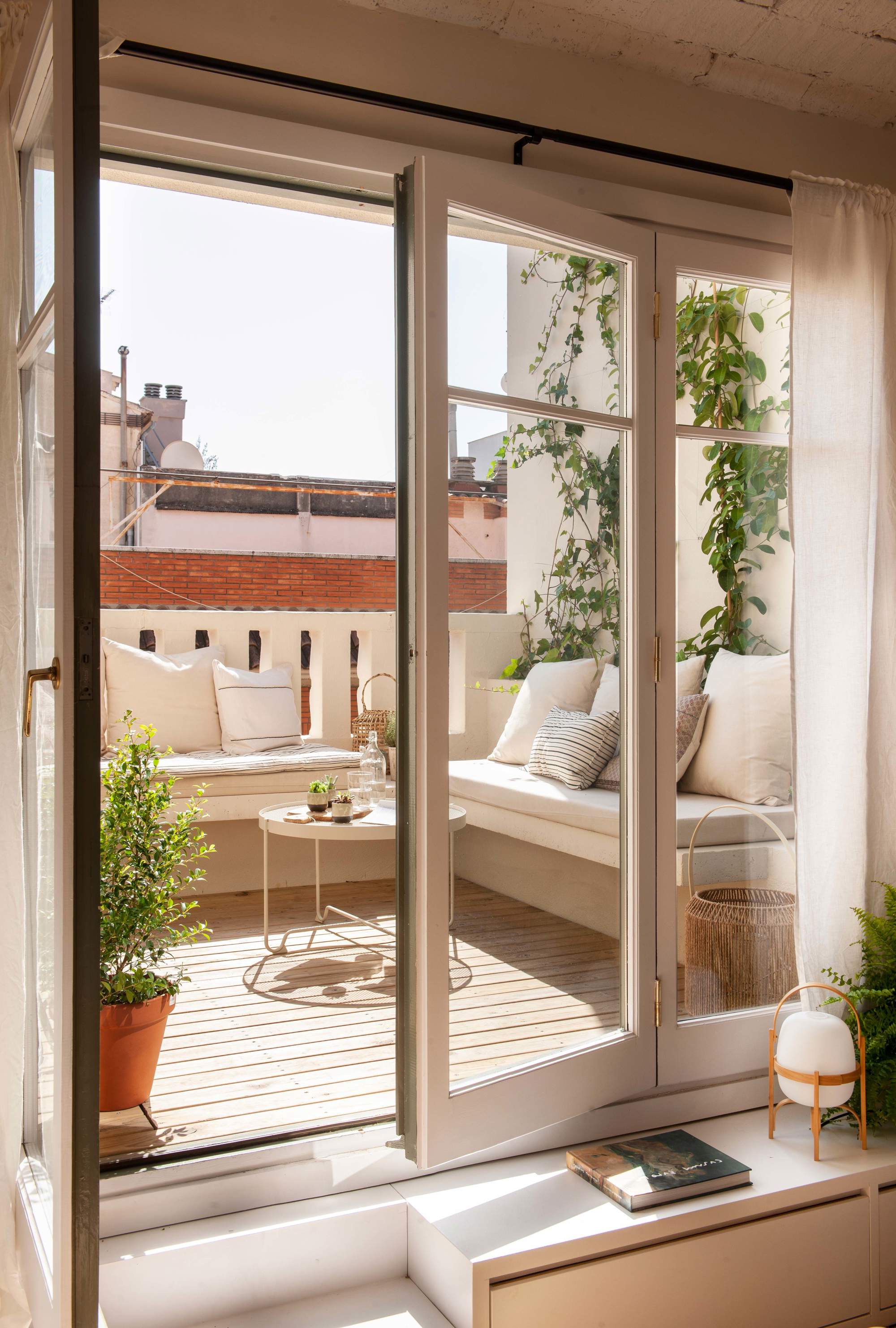 Terraza pequeña con sofá de obra en blanco total